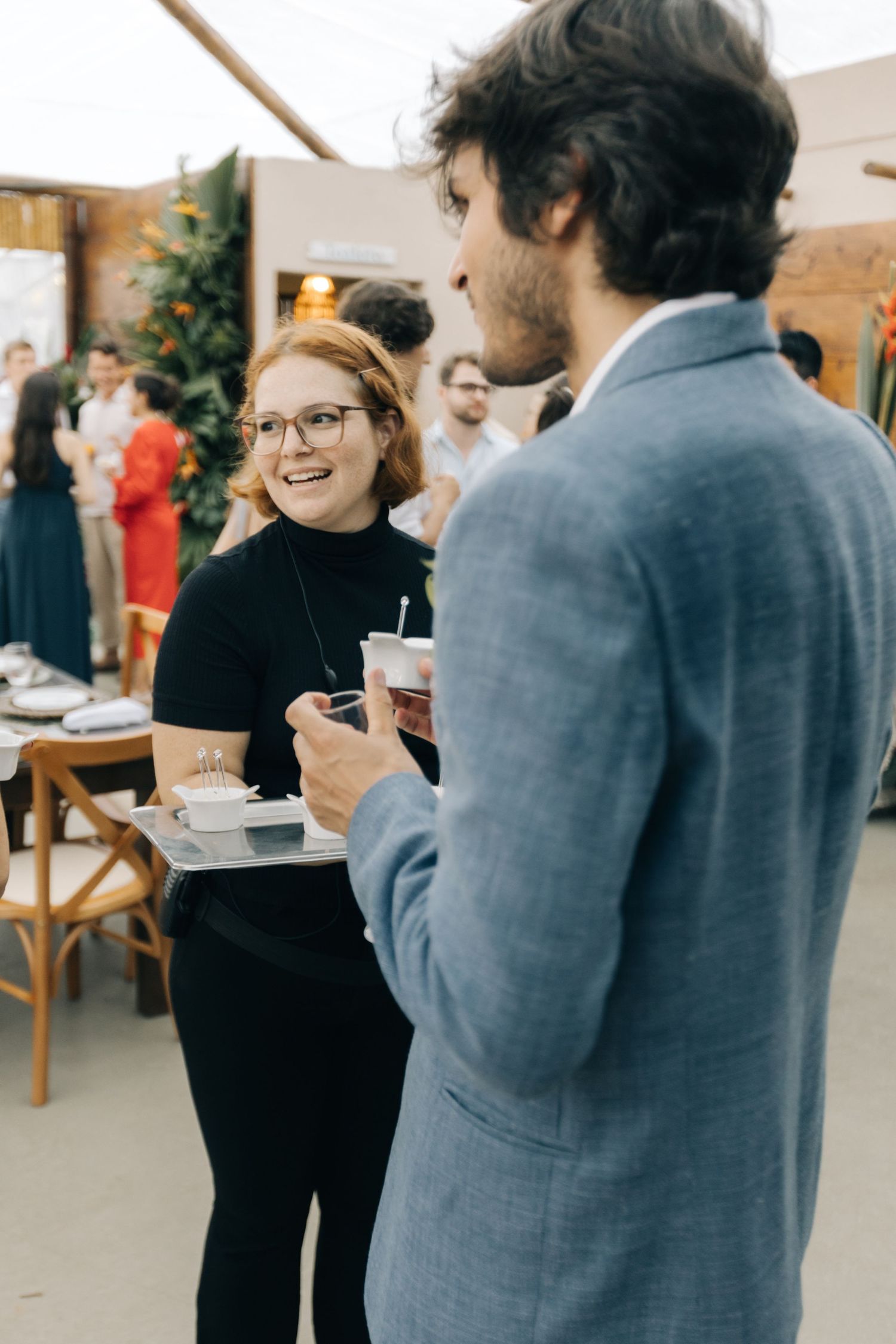 Two people in casual attire having an animated conversation indoors.