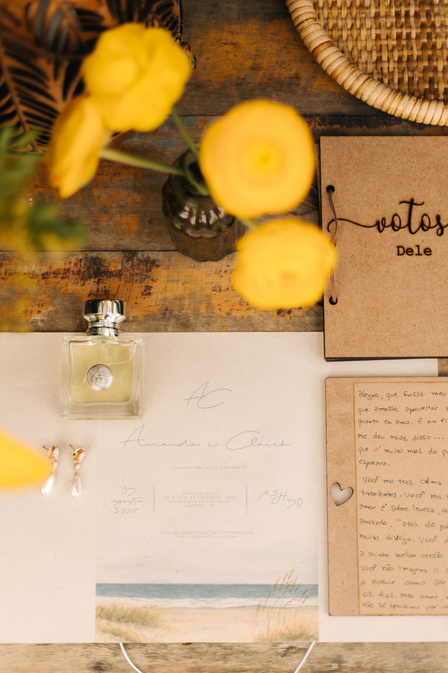 Wedding stationery flatlay with yellow flowers, perfume bottle, and vintage notes.