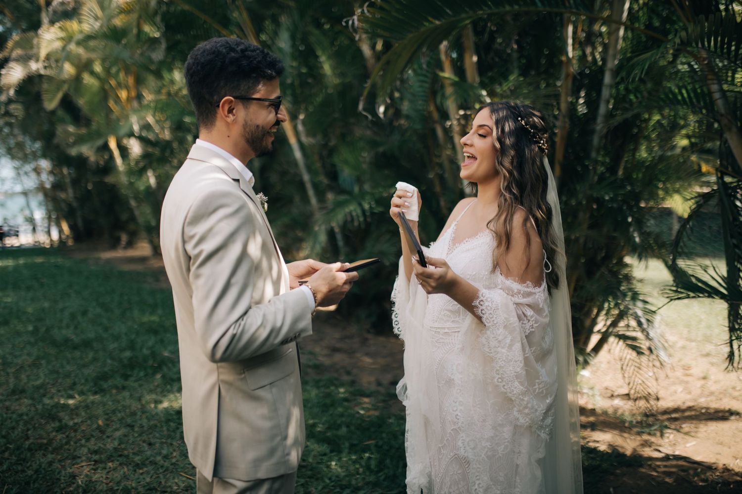 Couple exchanging vows or reading letters during an outdoor wedding ceremony.