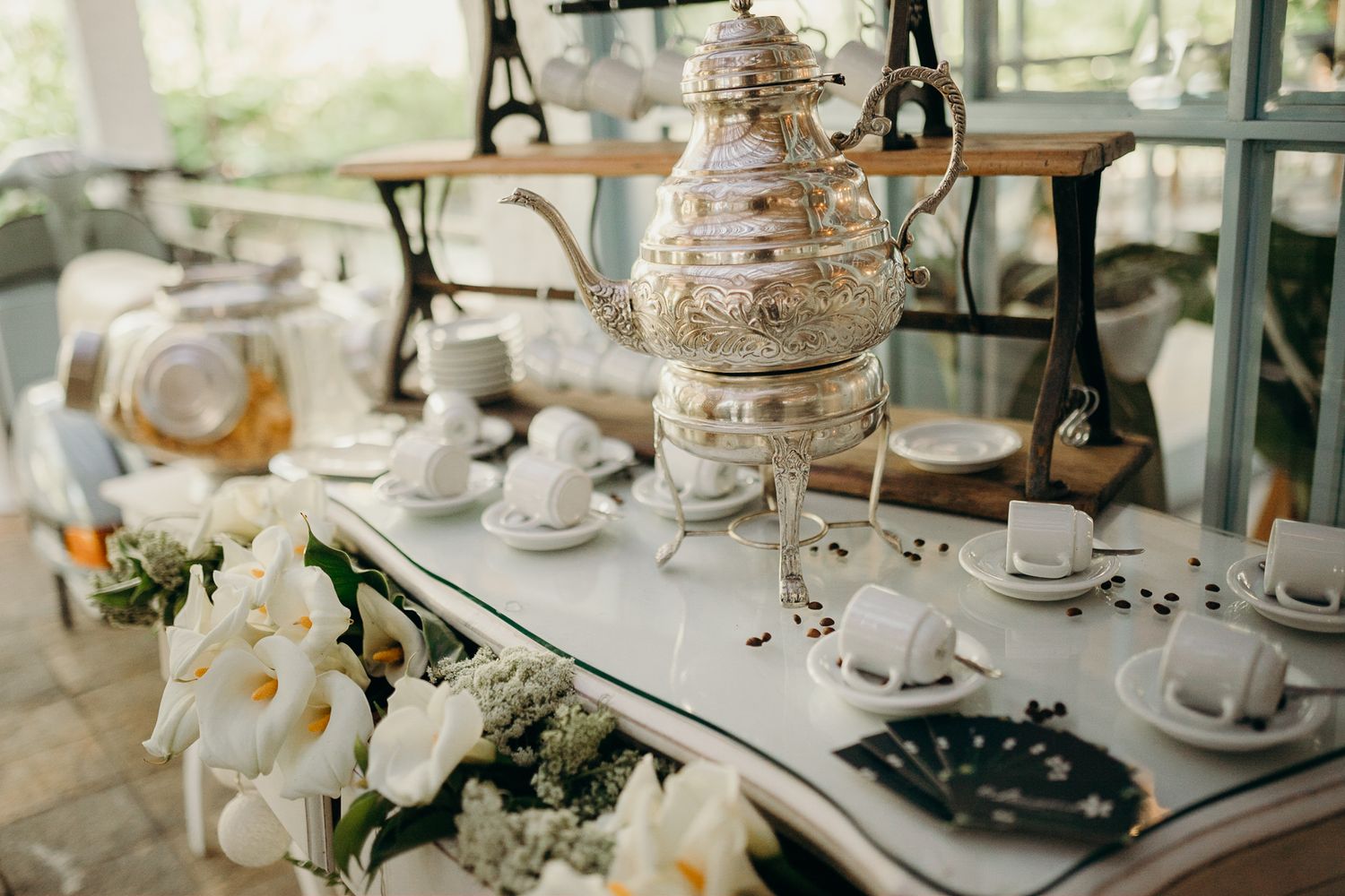 Elegant table settings with crystal glassware and white floral centerpieces.