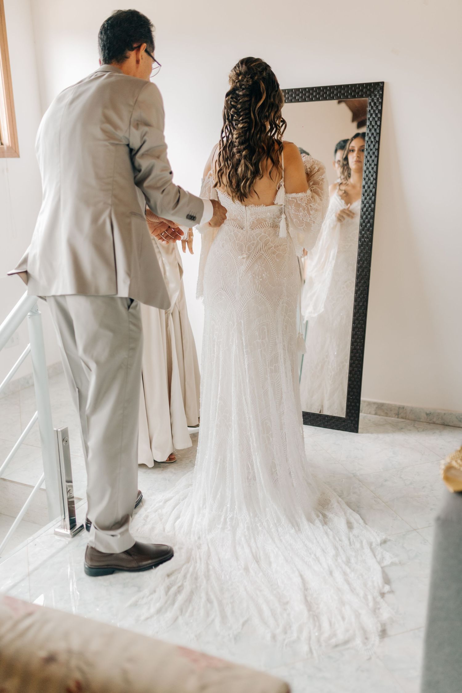 Back view of wedding dress with long train during final fitting.