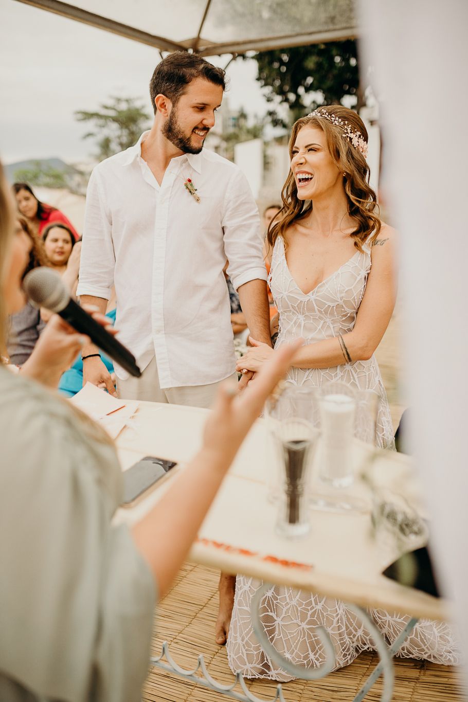 Romantic moment captured during beach wedding reception under white tent.