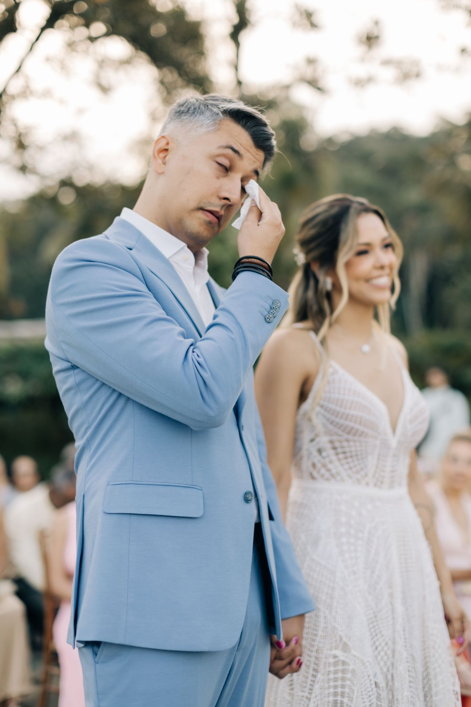 Couple sharing an emotional moment during a wedding ceremony in an outdoor setting.
