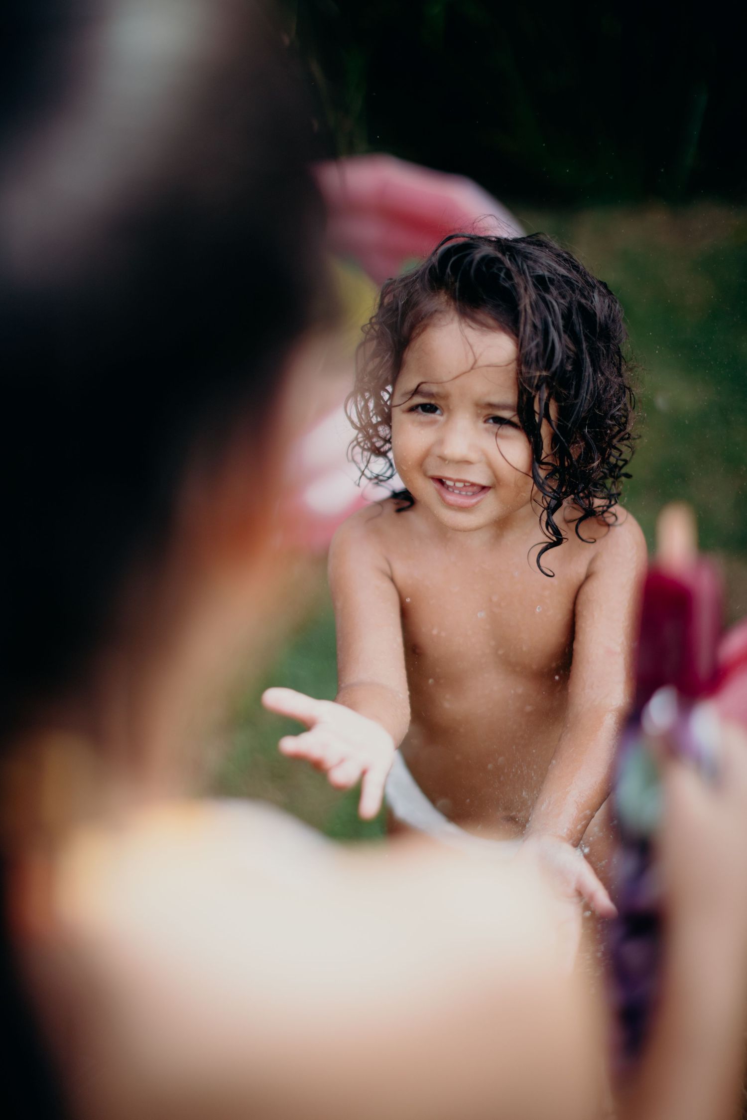 A candid playful moment captured during outdoor summer fun with water.
