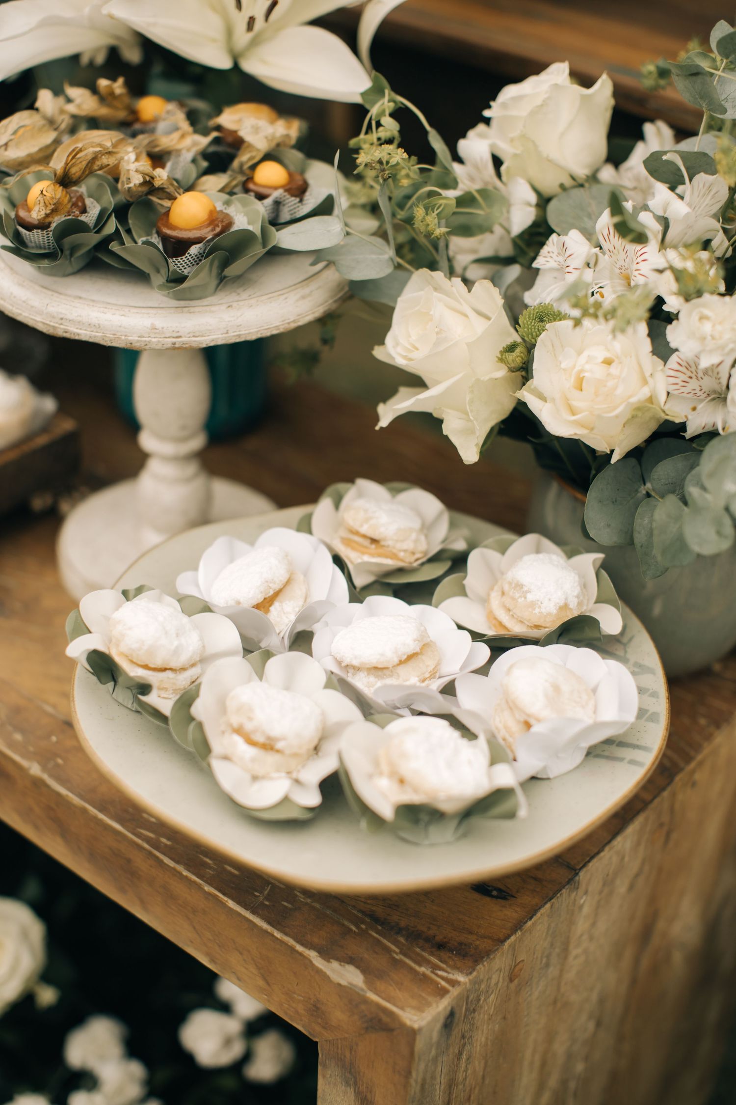 Delicate white floral arrangements and appetizers presented on tiered cake stands.