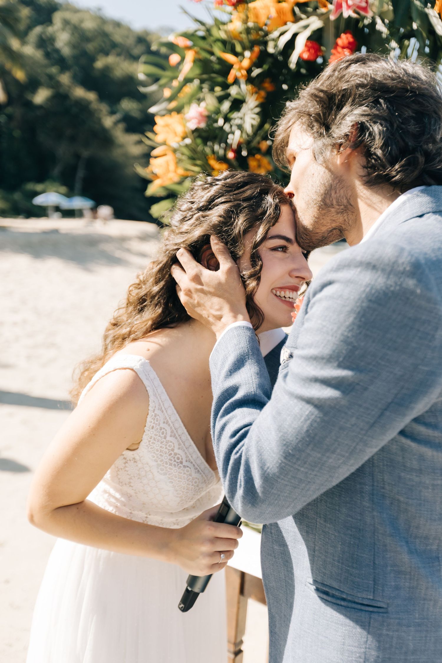 A couple shares a romantic moment during their beach wedding ceremony.