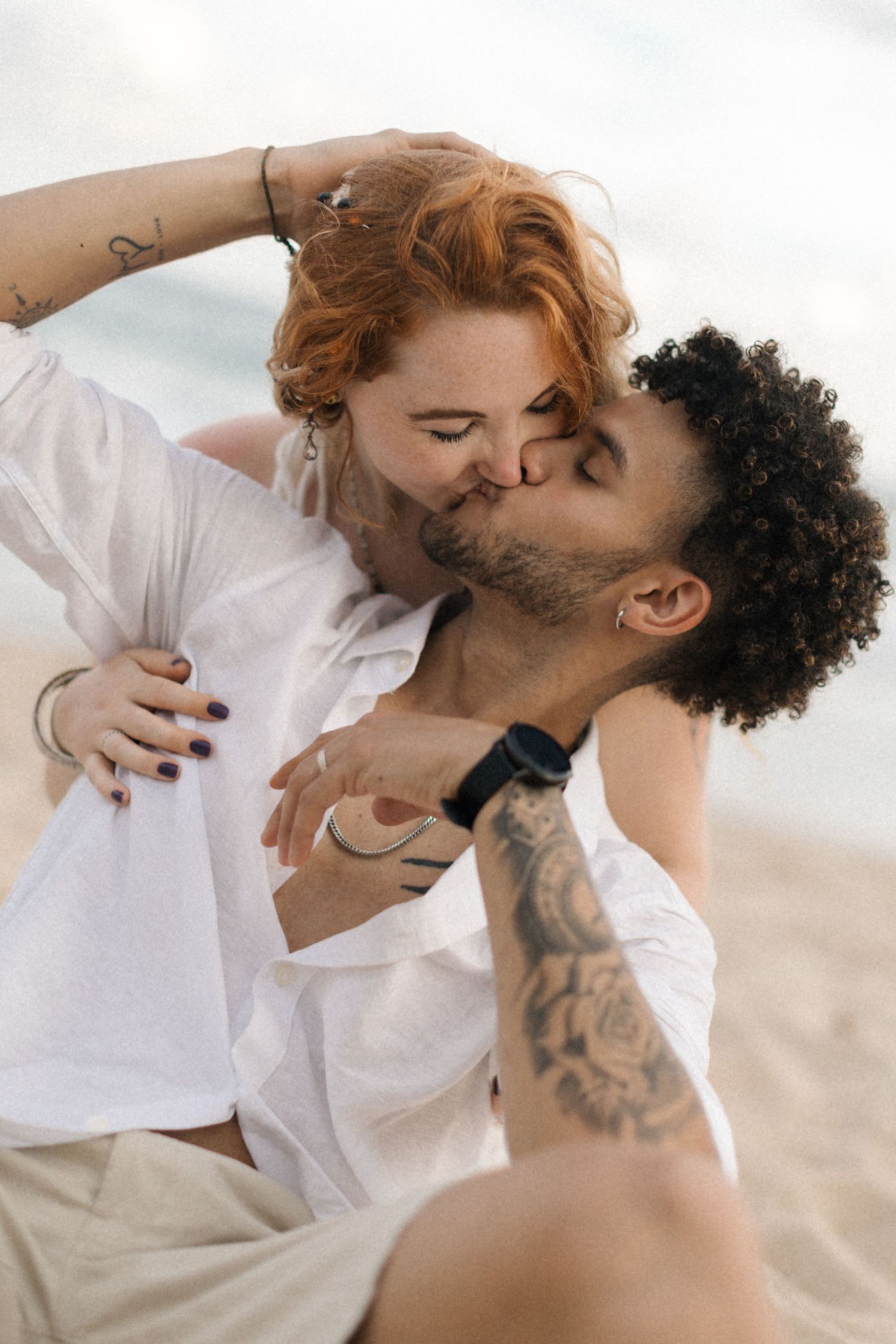 A tender romantic moment captured between a couple in white clothing.