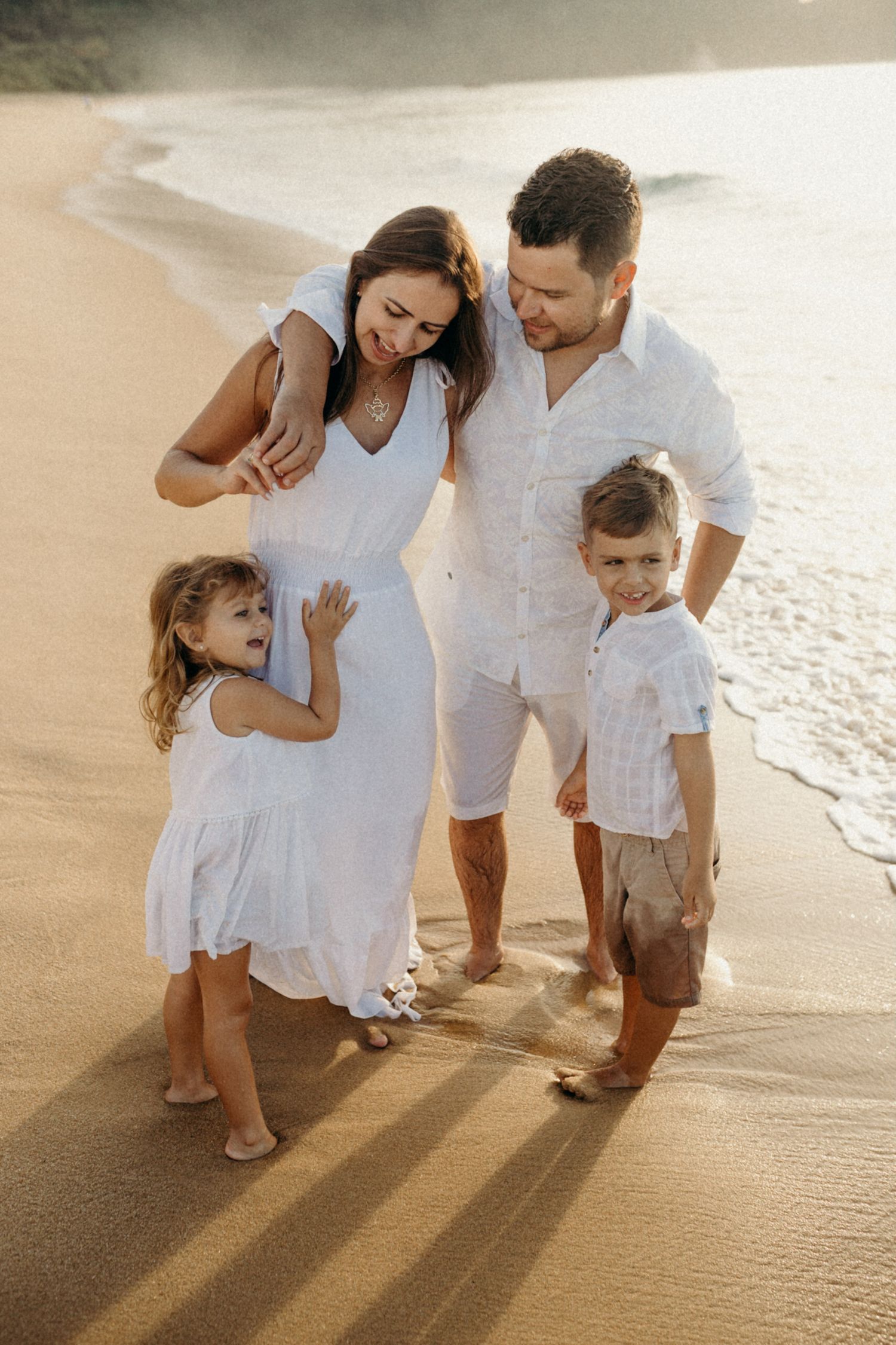Candid family beach photos showing loving interactions at sunset.