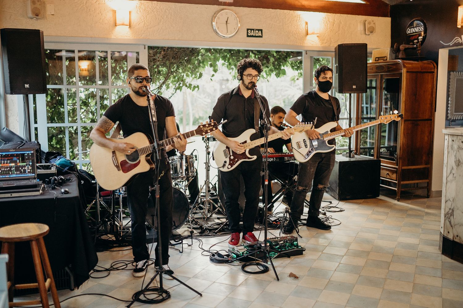 Musicians perform at an indoor wedding venue with wooden beams and ambient lighting.