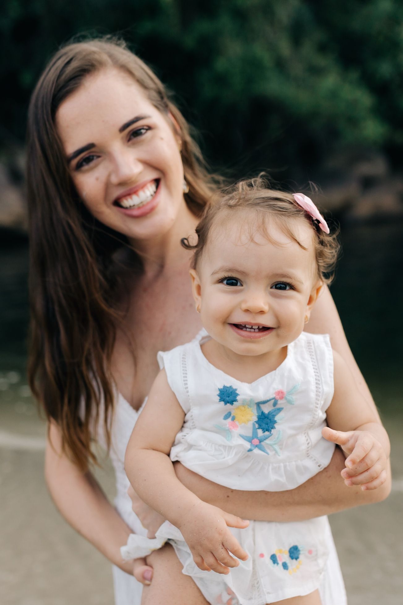 A joyful family moment captured in white clothing outdoors.