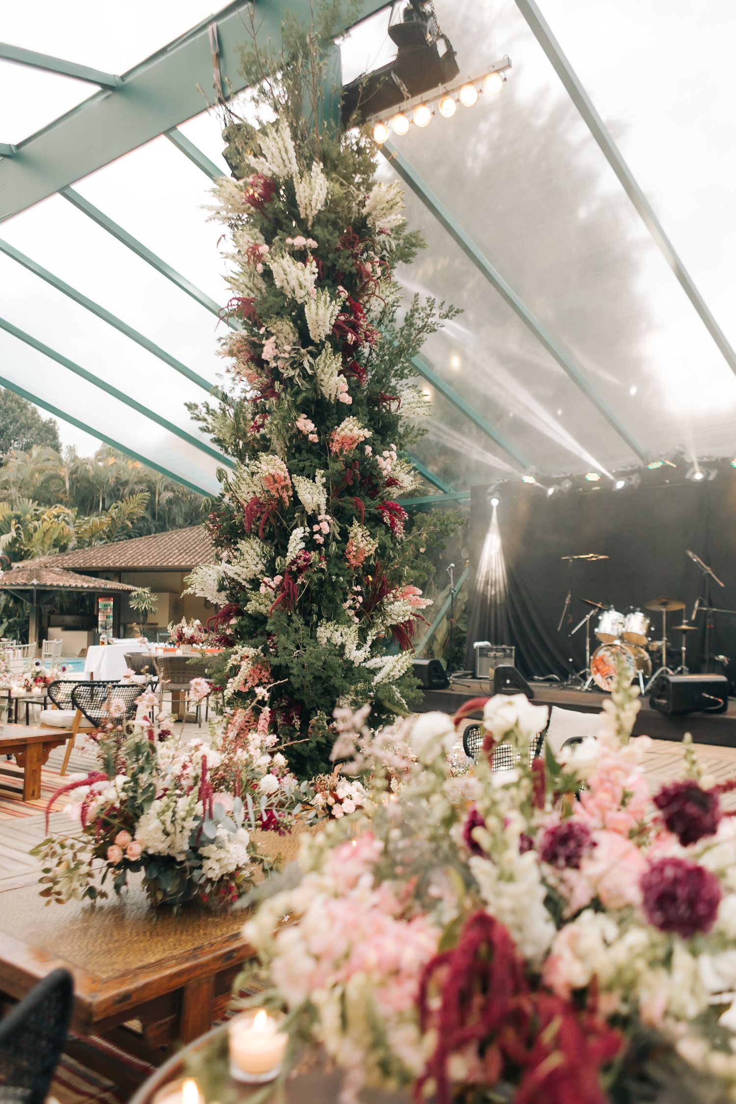 A stunning floral arrangement with white and pink blooms decorates a covered outdoor venue.