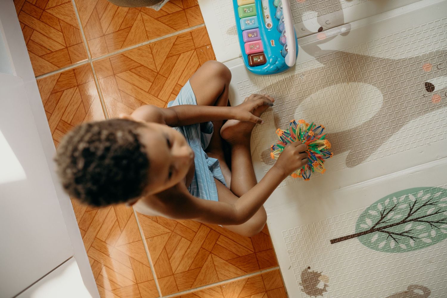 An intimate indoor playtime scene with toys and family on the floor.