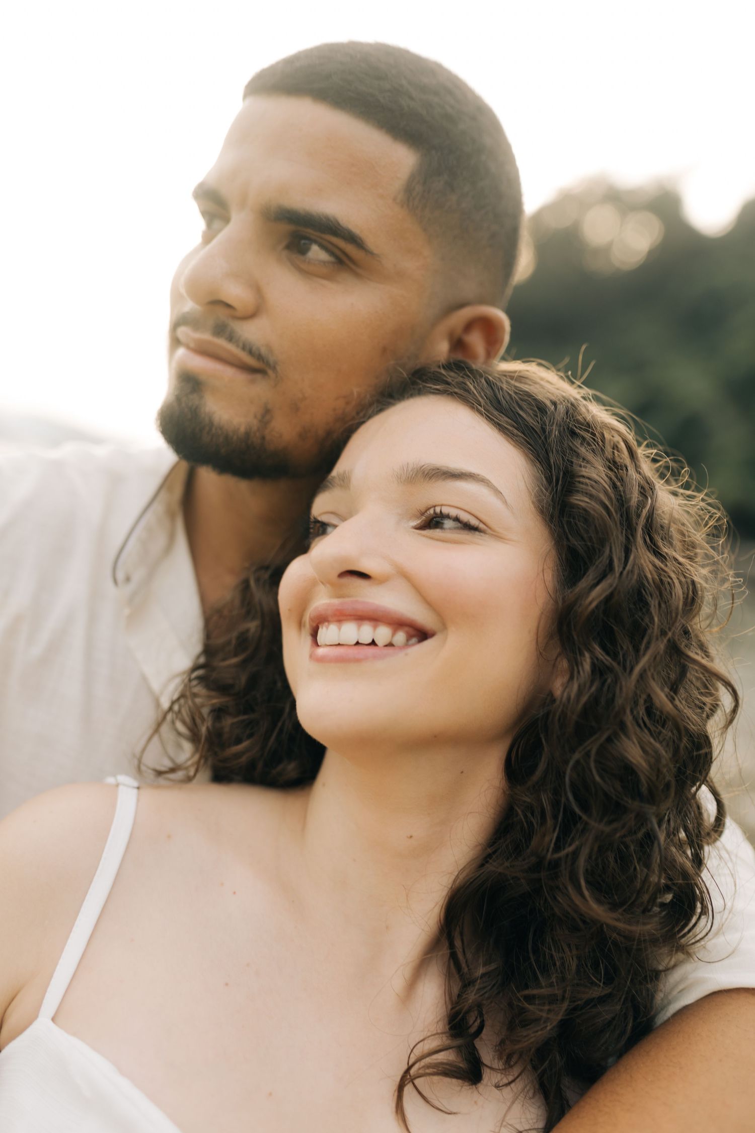 A couple shares a joyful moment together during their beach photoshoot at sunset.