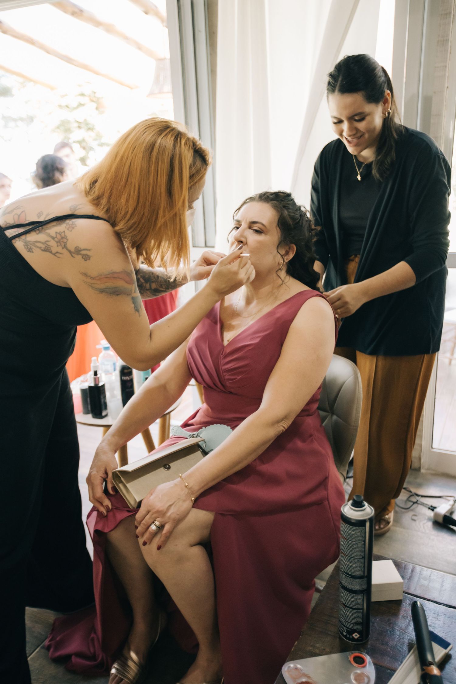 Wedding preparation moment with makeup application in a bright indoor setting.