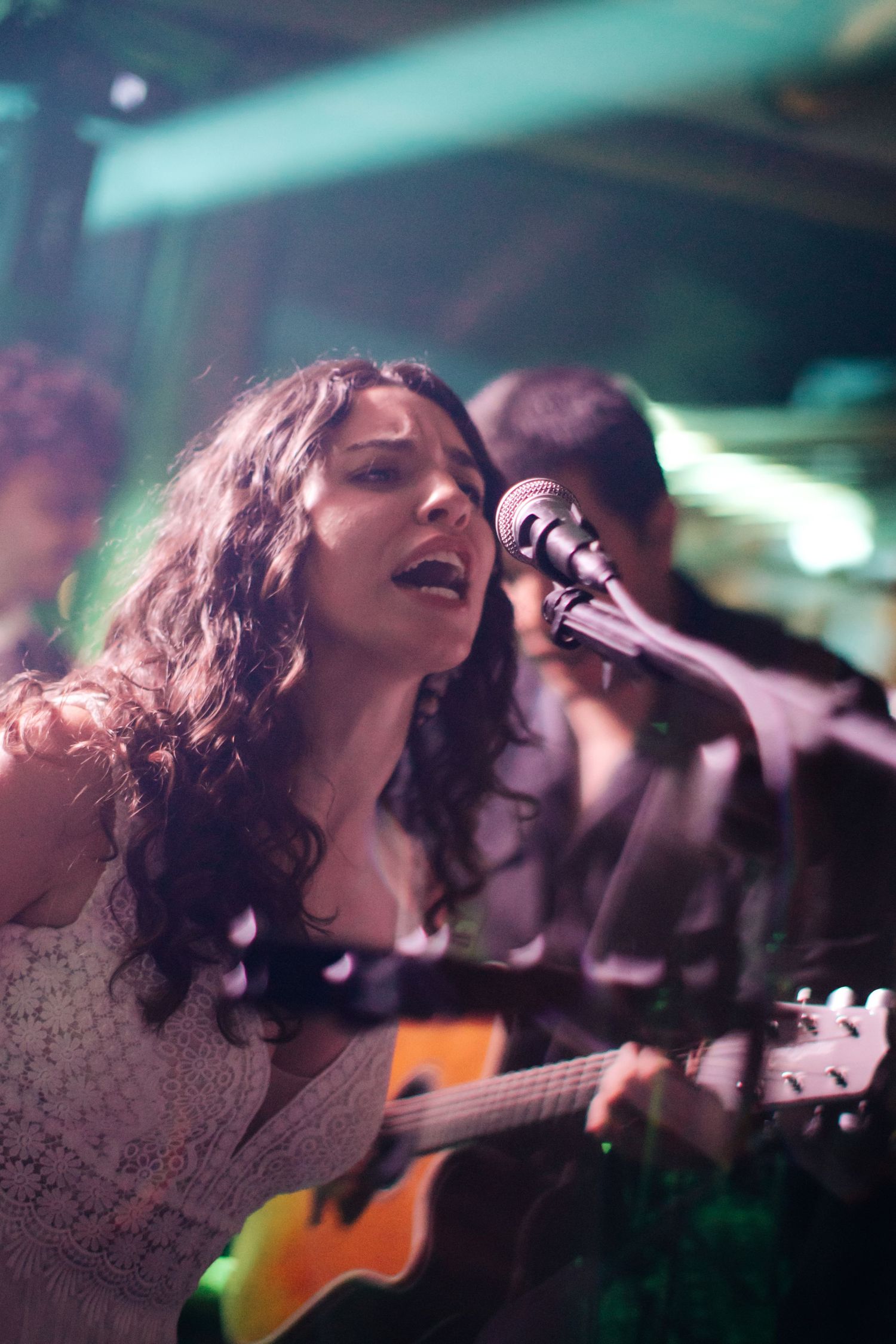 Dramatic performance shots showing passionate singing in colorful stage lighting.