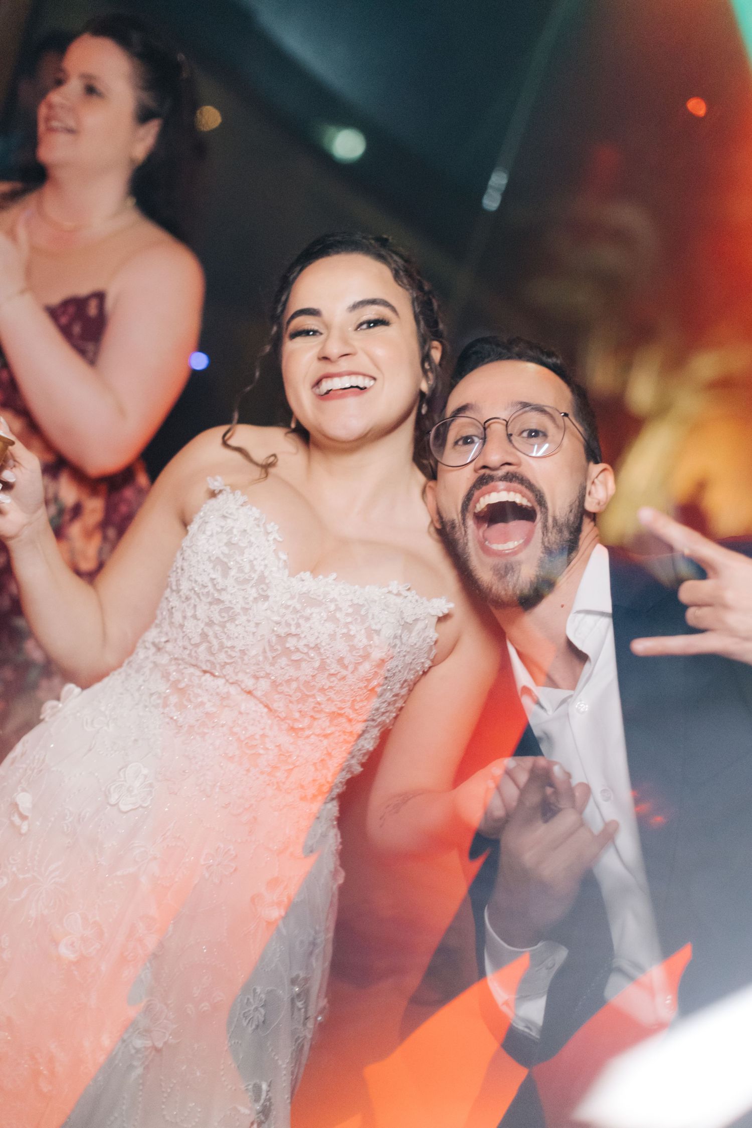 Energetic dance floor moments captured with warm lighting at a wedding reception.