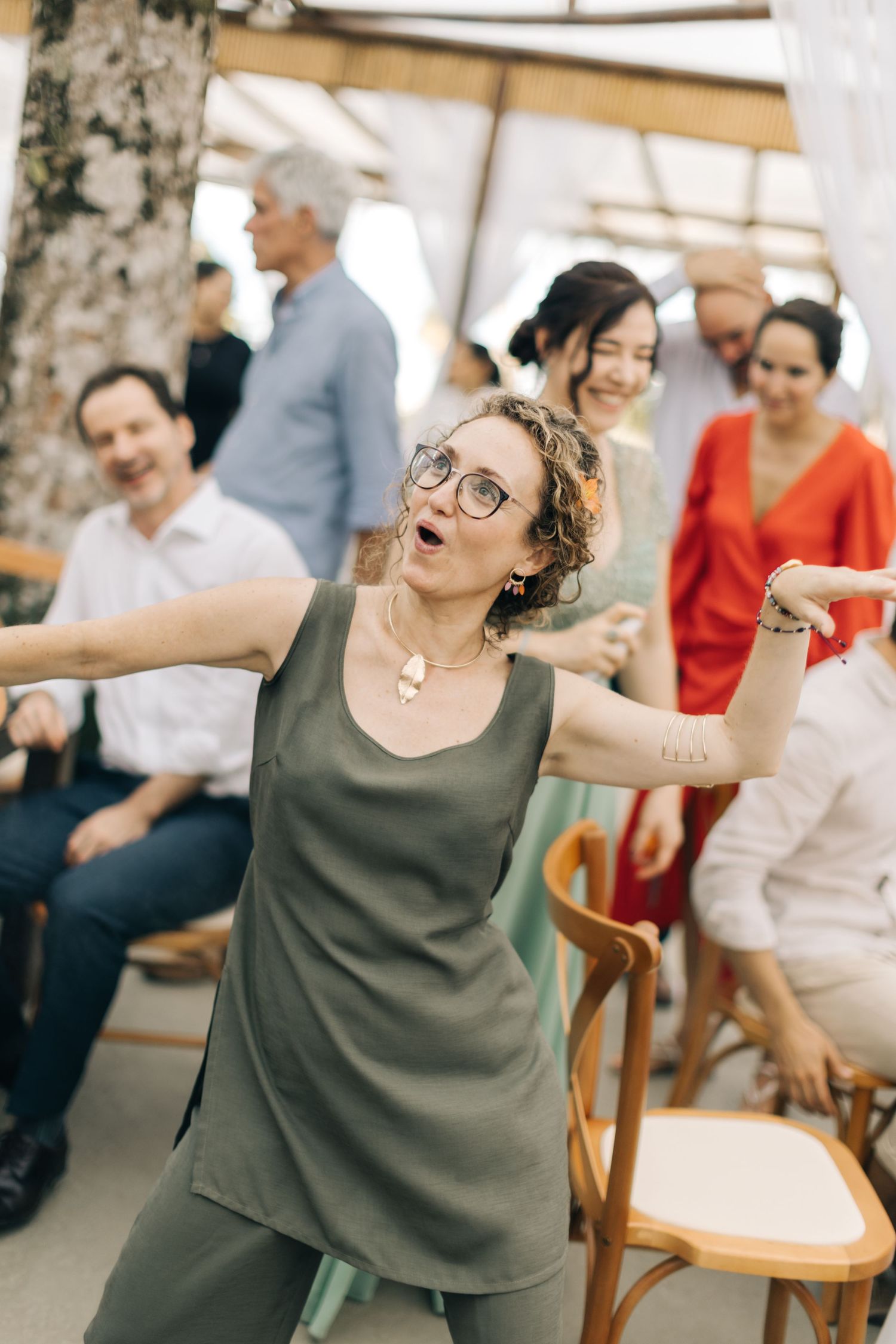 Wedding guests laugh and celebrate during a joyful reception moment.