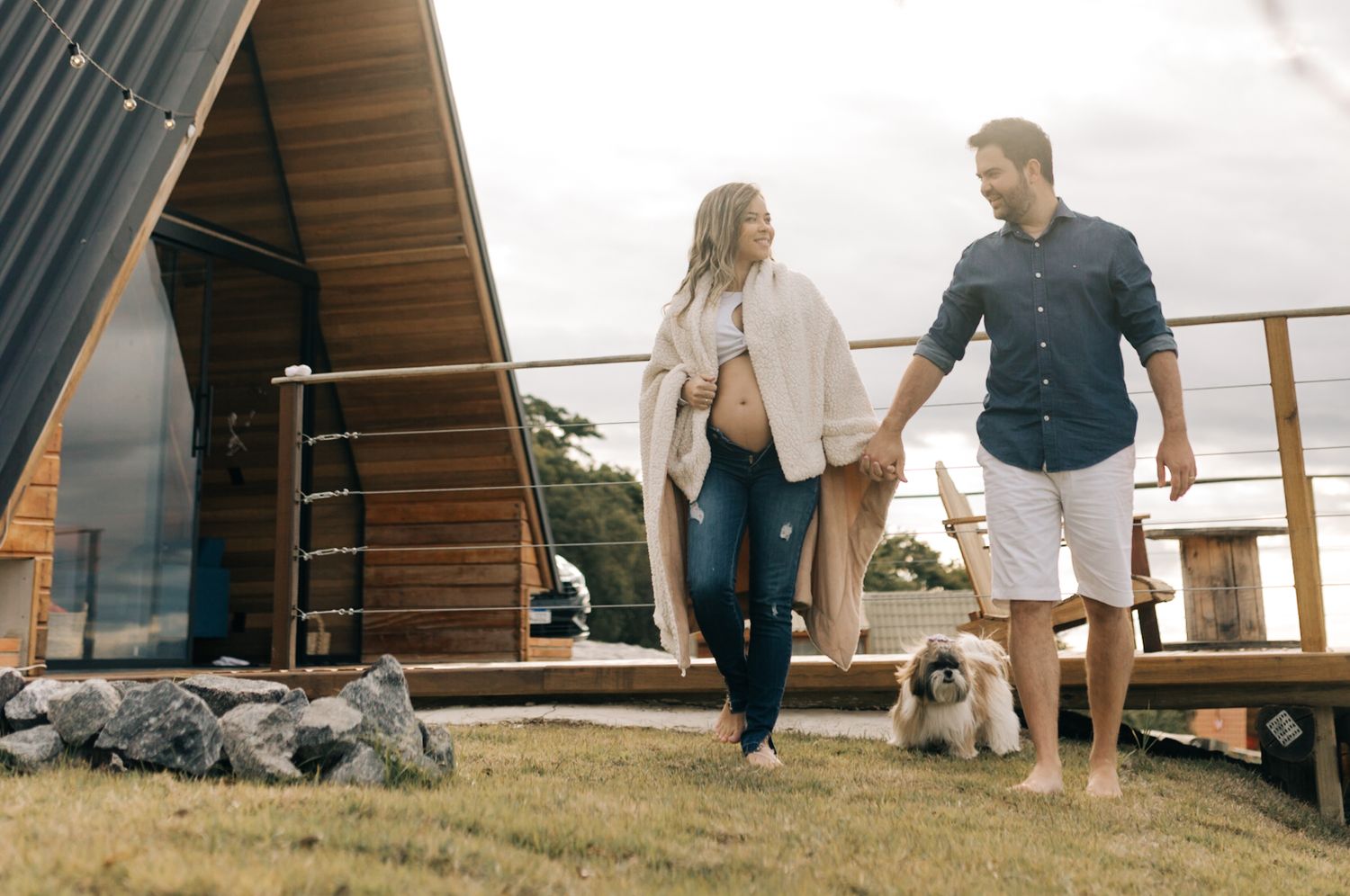 Couple sharing tender moments outside an A-frame cabin with their dog nearby.