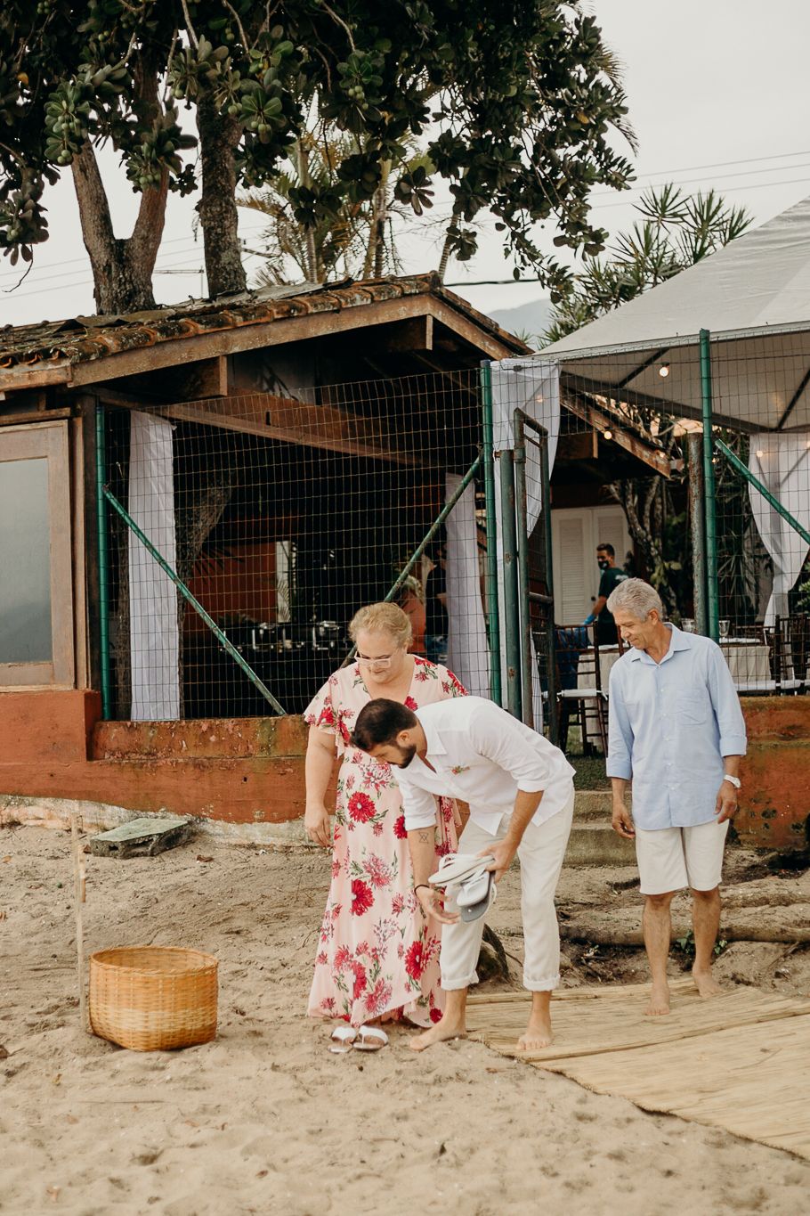 People walking together on a wooden boardwalk at a beachside venue.