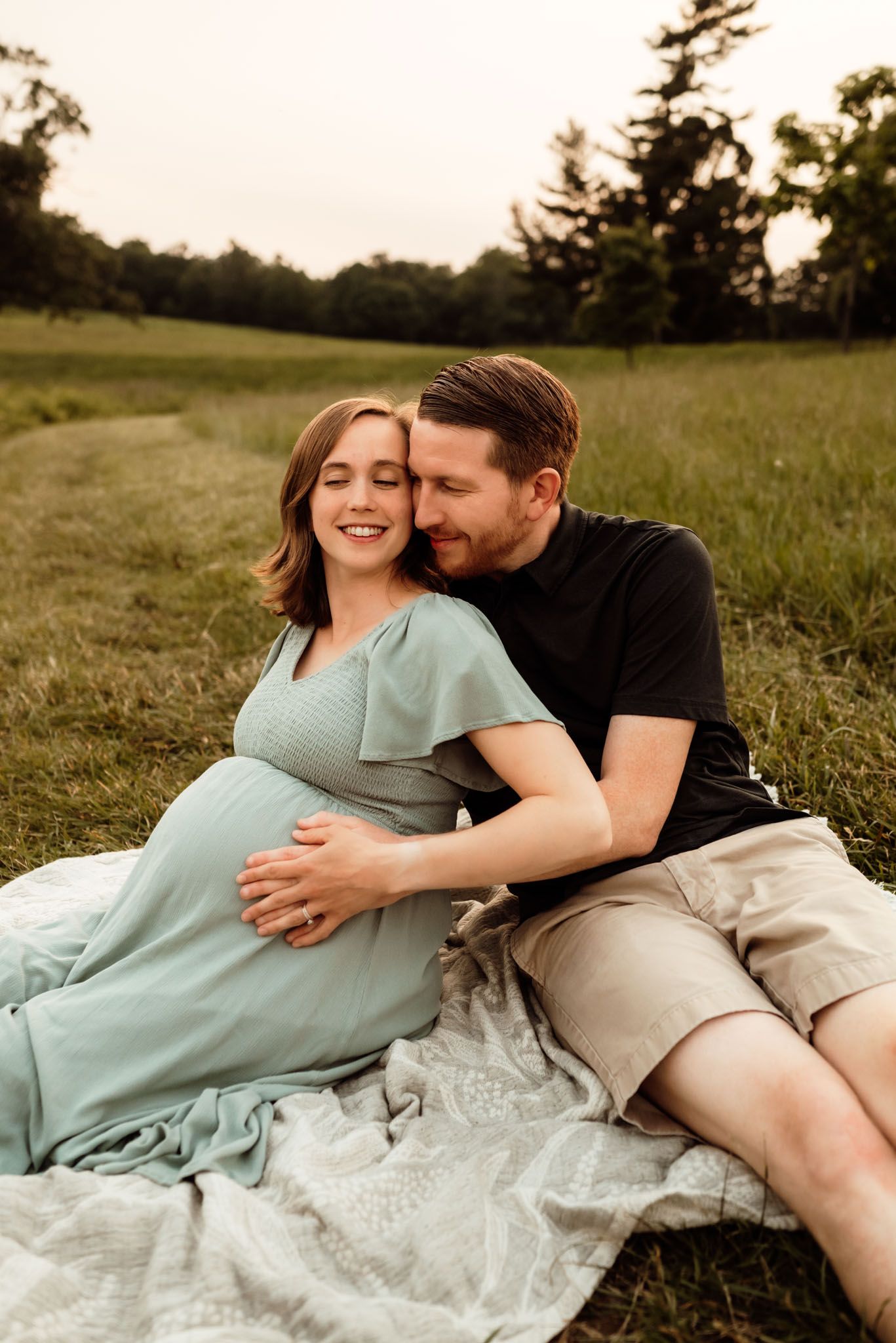 Couple kissing during maternity portraits, golden hour photography, Collegeville PA