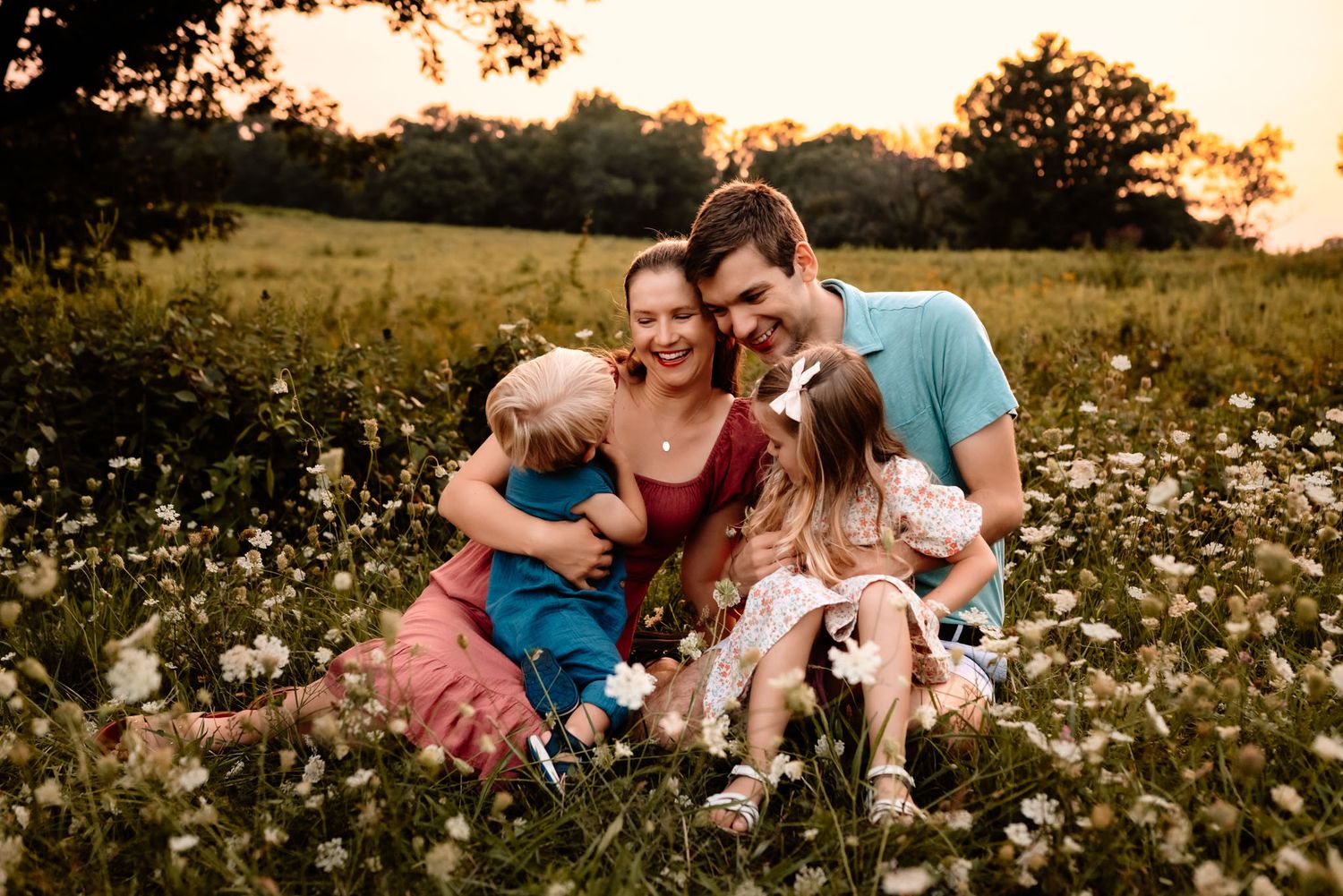 Family of four cuddling on blanket in grass, lifestyle family photography, Collegeville PA