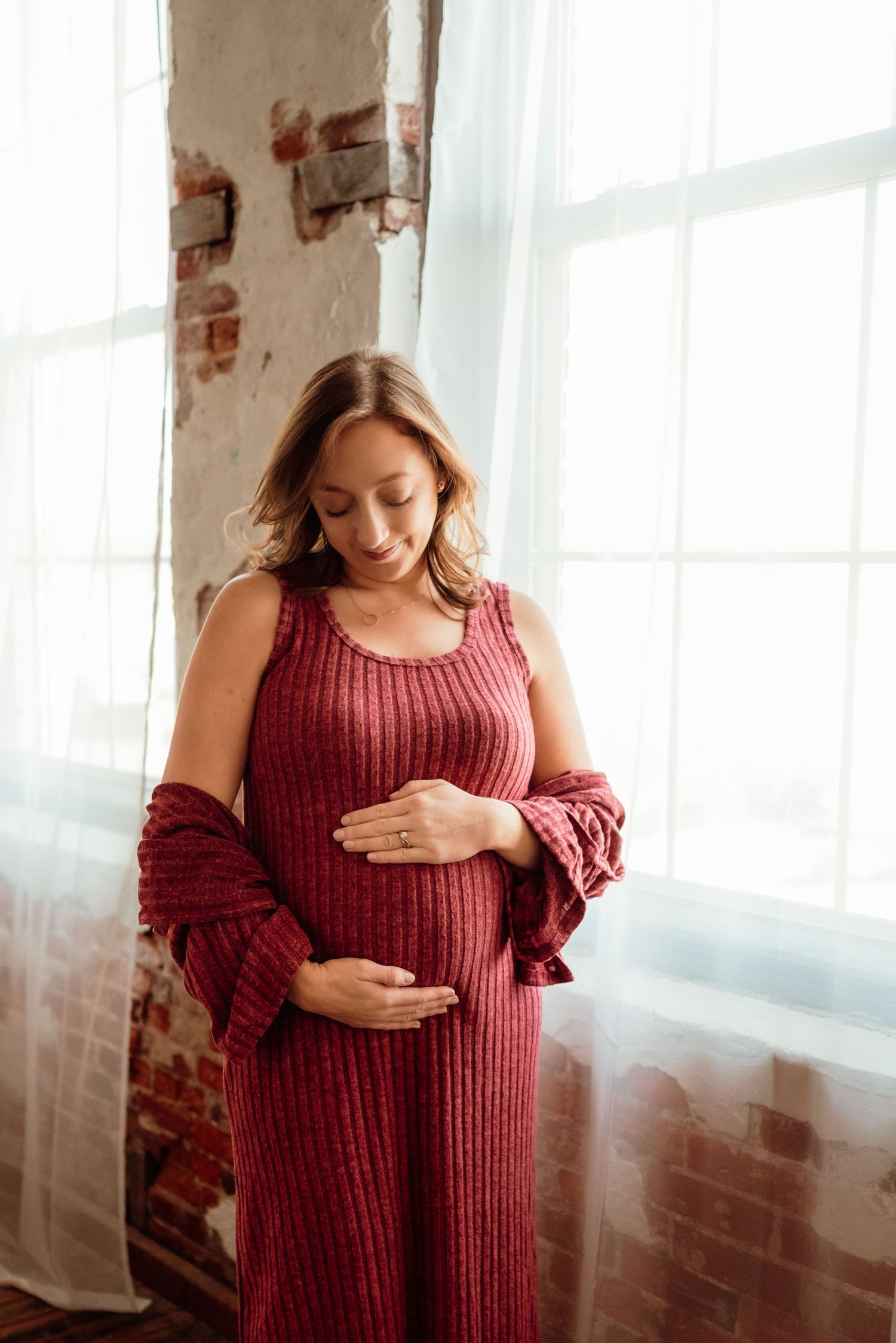 beautiful mom-to-be cradling belly in studio in philadelphia