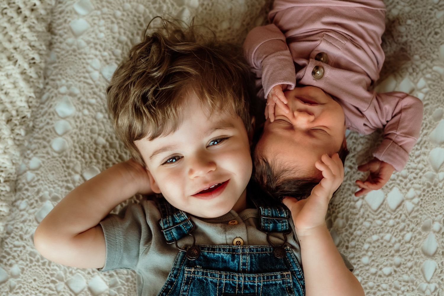 Family and siblings embracing and cradling new baby, studio session, King of Prussia, PA