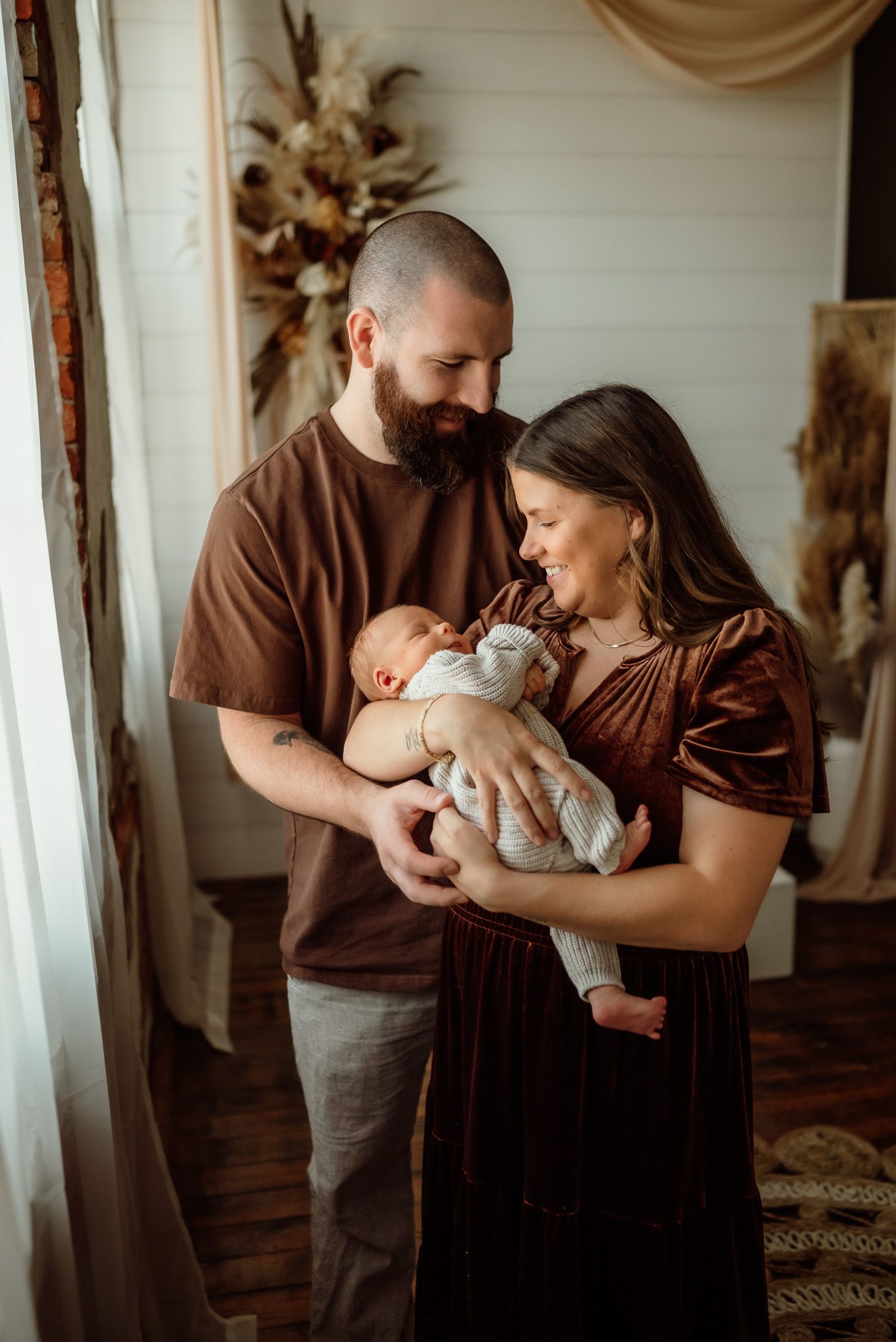 Couple cuddling and tenderely holding their newborn, emotional newborn portrait, Phoenixville, PA