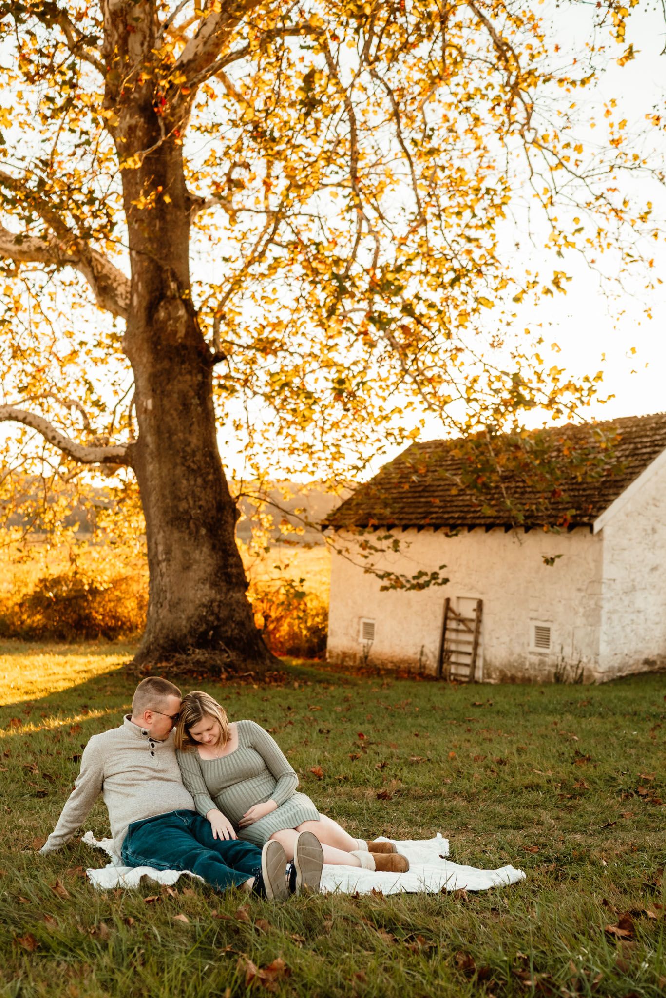 Couple kissing during maternity portraits, golden hour photography, Collegeville PA