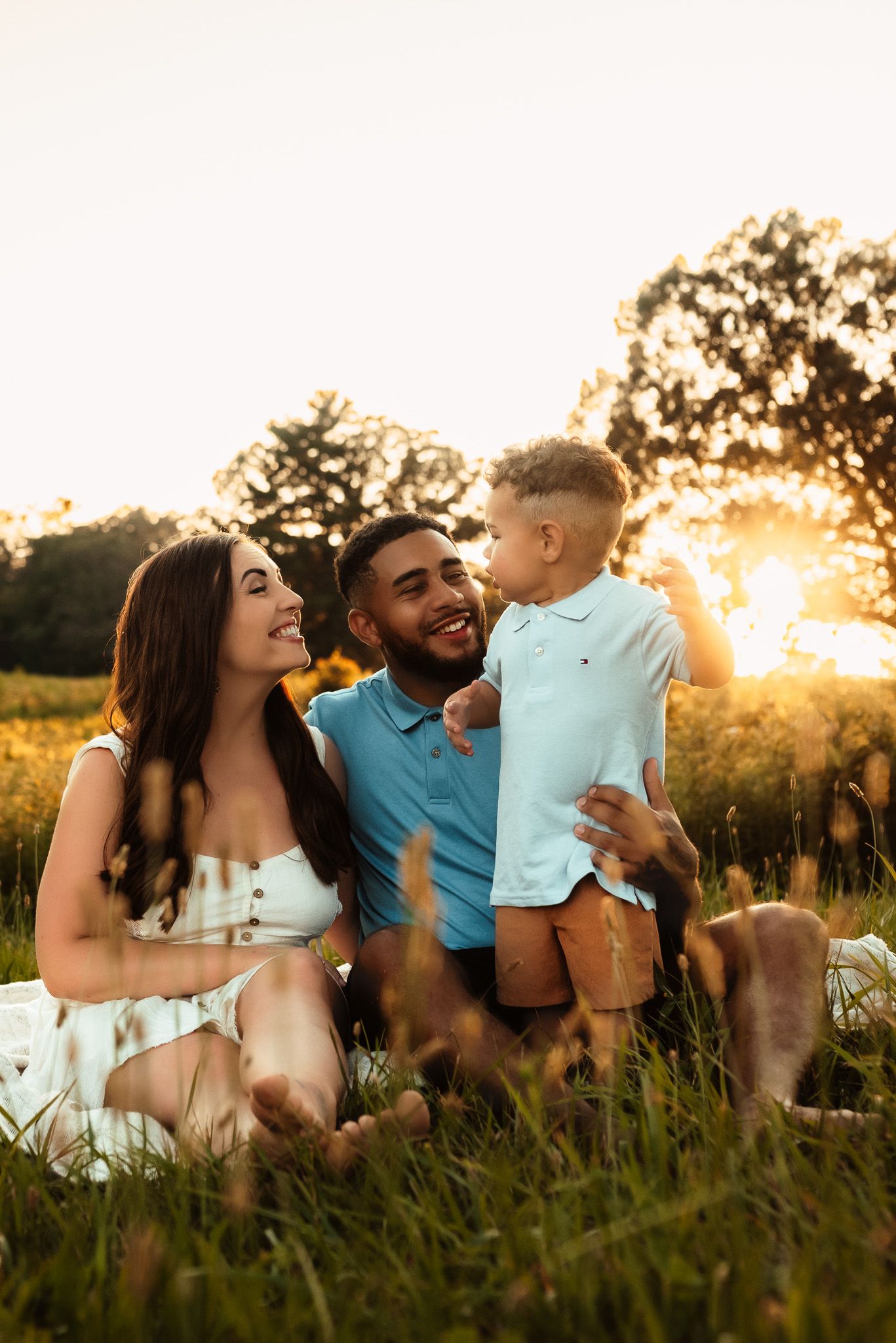 Family of four cuddling on blanket in grass, lifestyle family photography, Collegeville PA