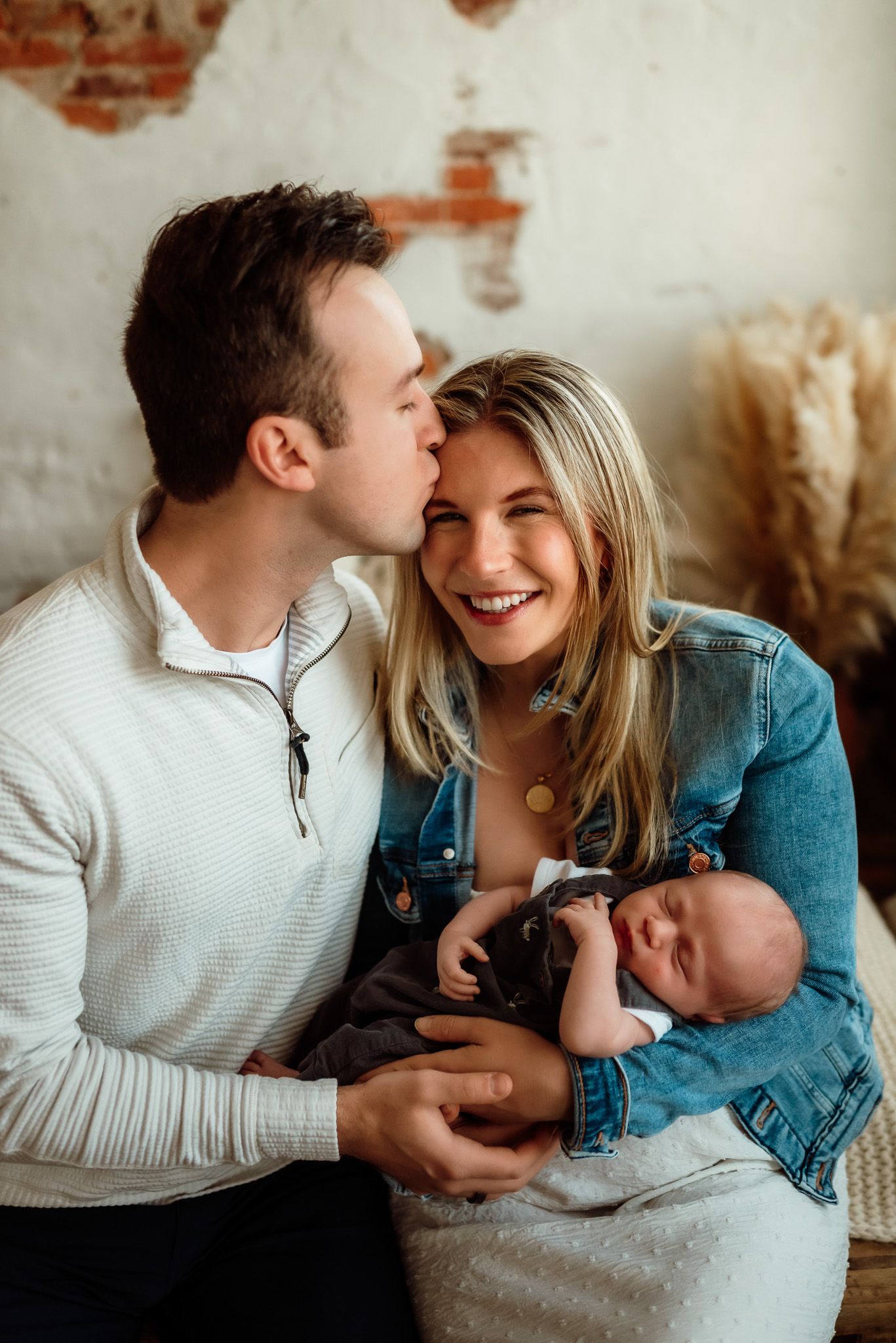 Couple cuddling and tenderely holding their newborn, emotional newborn portrait, Phoenixville, PA