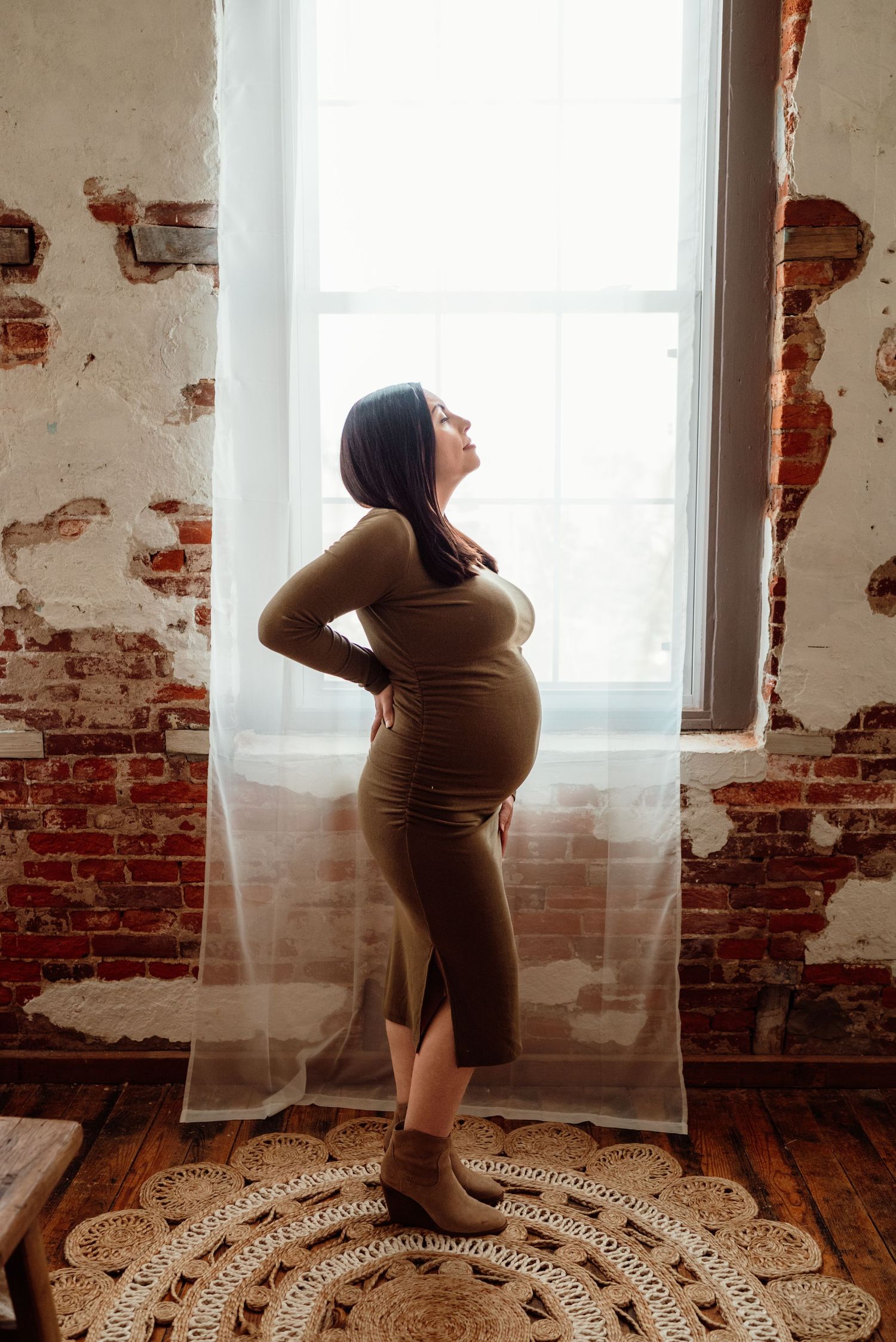 beautiful mom-to-be cradling belly in studio in philadelphia