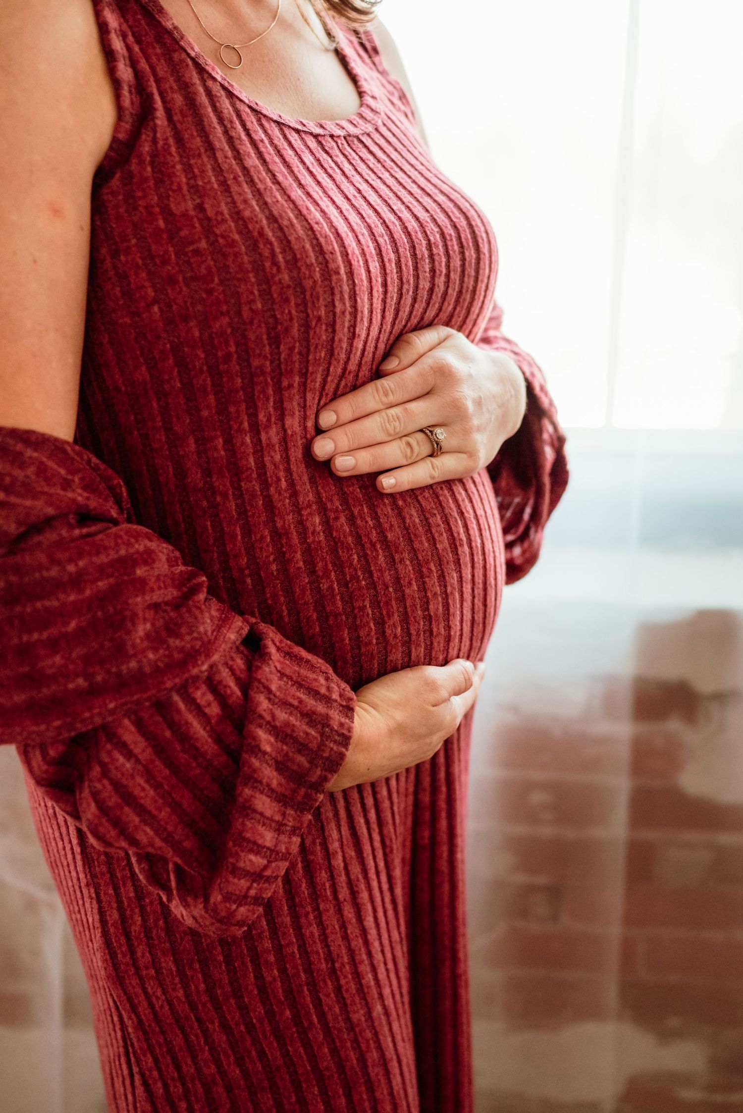 beautiful mom-to-be cradling belly in studio in philadelphia