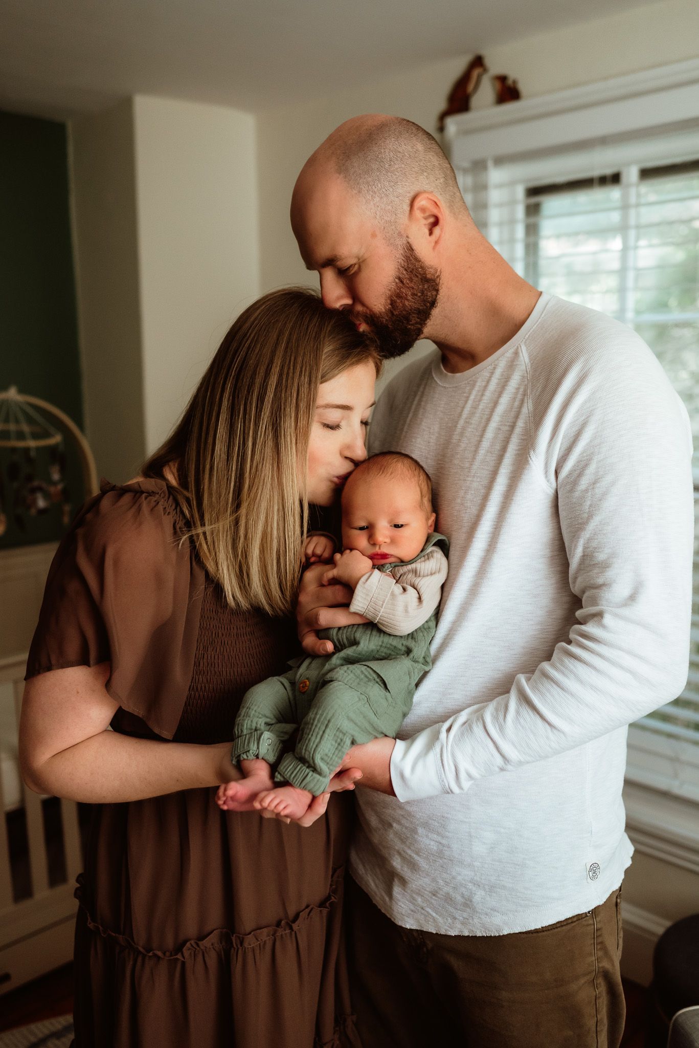 Couple cuddling and tenderely holding their newborn, emotional newborn portrait, Phoenixville, PA