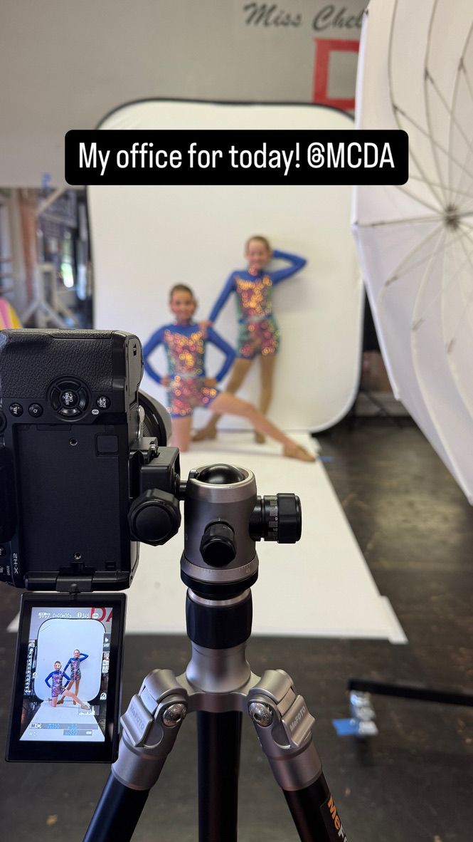 Photography equipment setup in a studio with white backdrop and lighting stands.