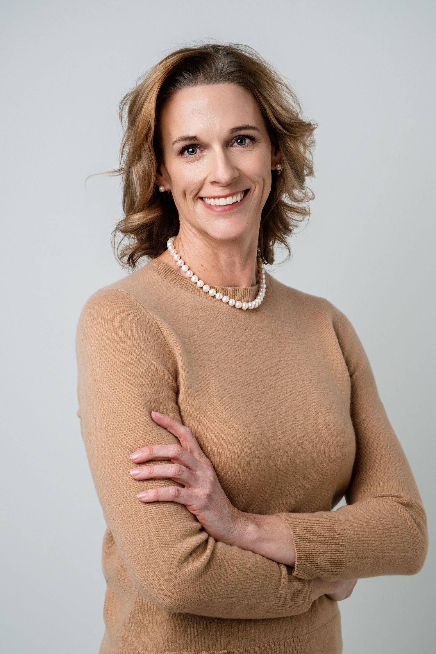 Professional studio portraits of a woman in a tan sweater showing different poses against a light background.