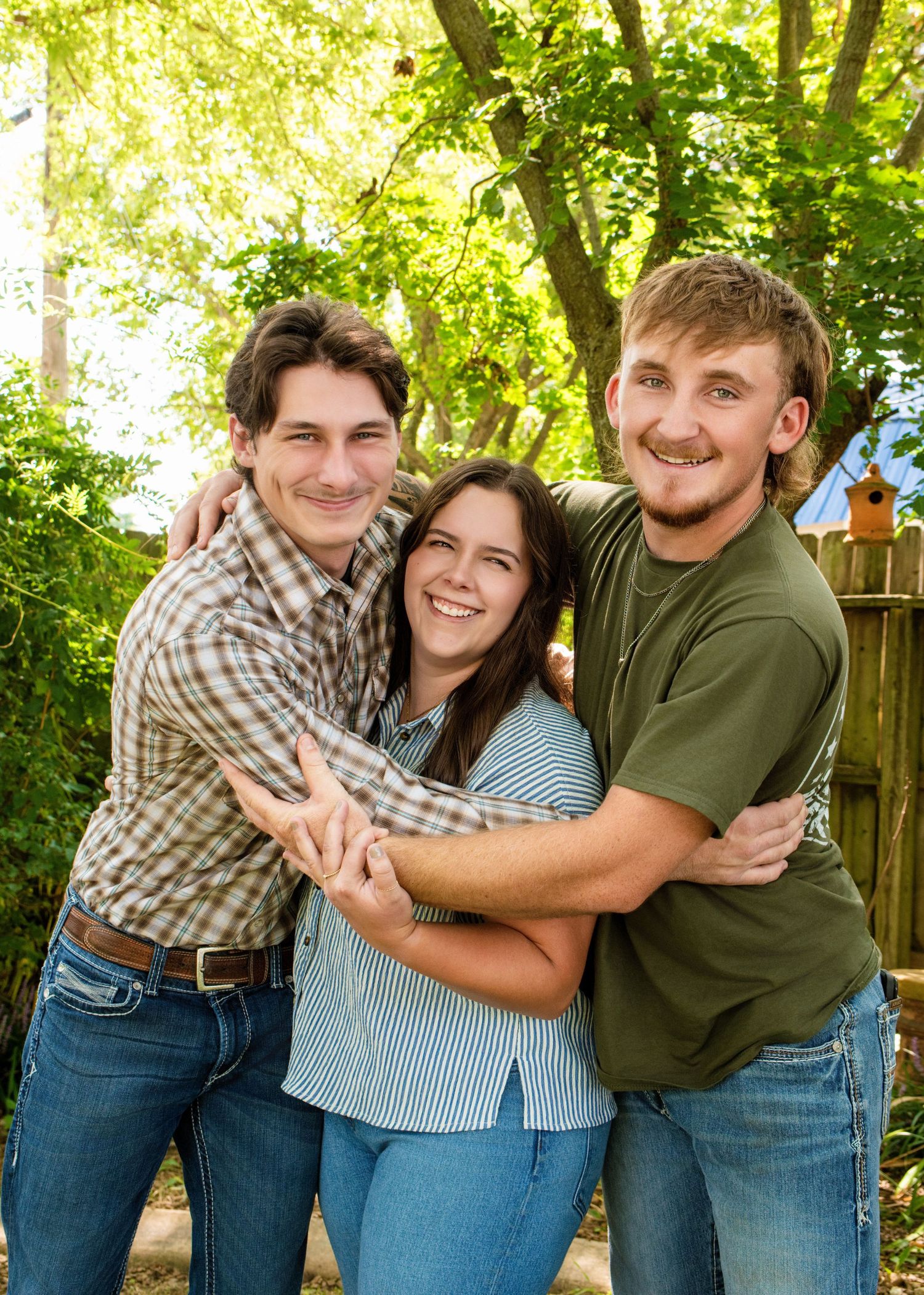 Candid family moment showing playful poses and hugs in outdoor garden setting.