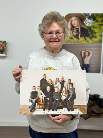 A series of photographs showing someone holding up family portrait prints and displaying them in different poses.