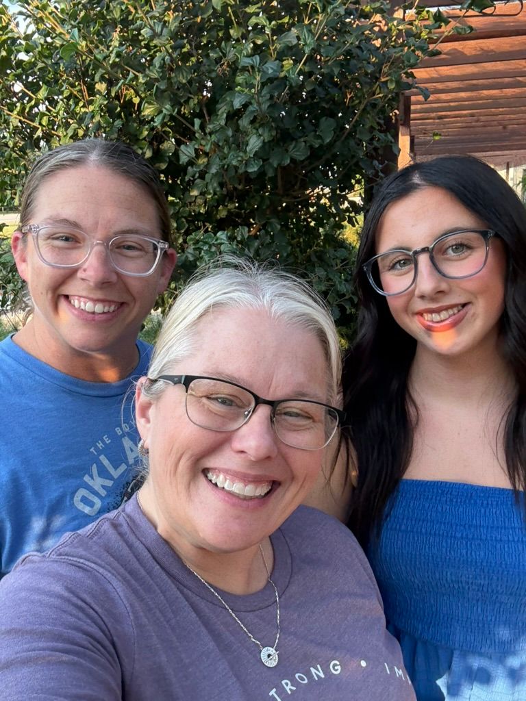 A series of selfies taken outdoors showing two people wearing glasses and smiling against a wooden wall background.