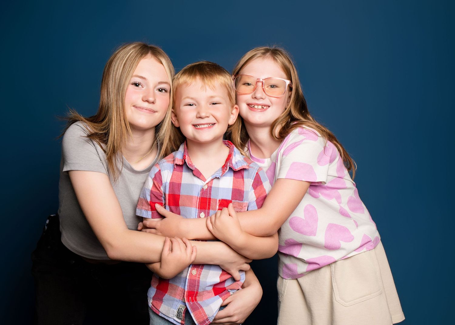 Studio portraits against blue backdrop showing playful group poses.