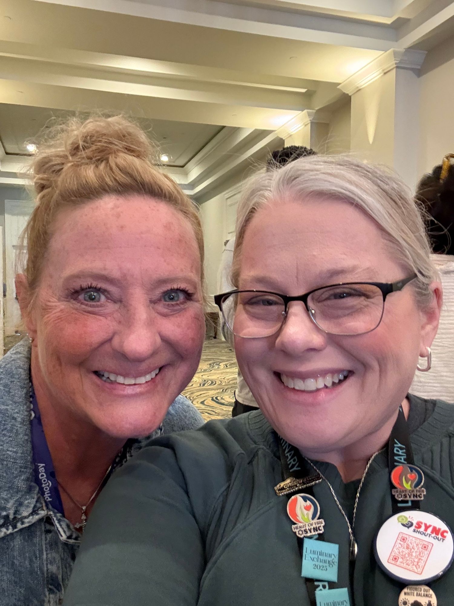 Two healthcare workers in scrubs share a series of cheerful selfies in a medical facility hallway.
