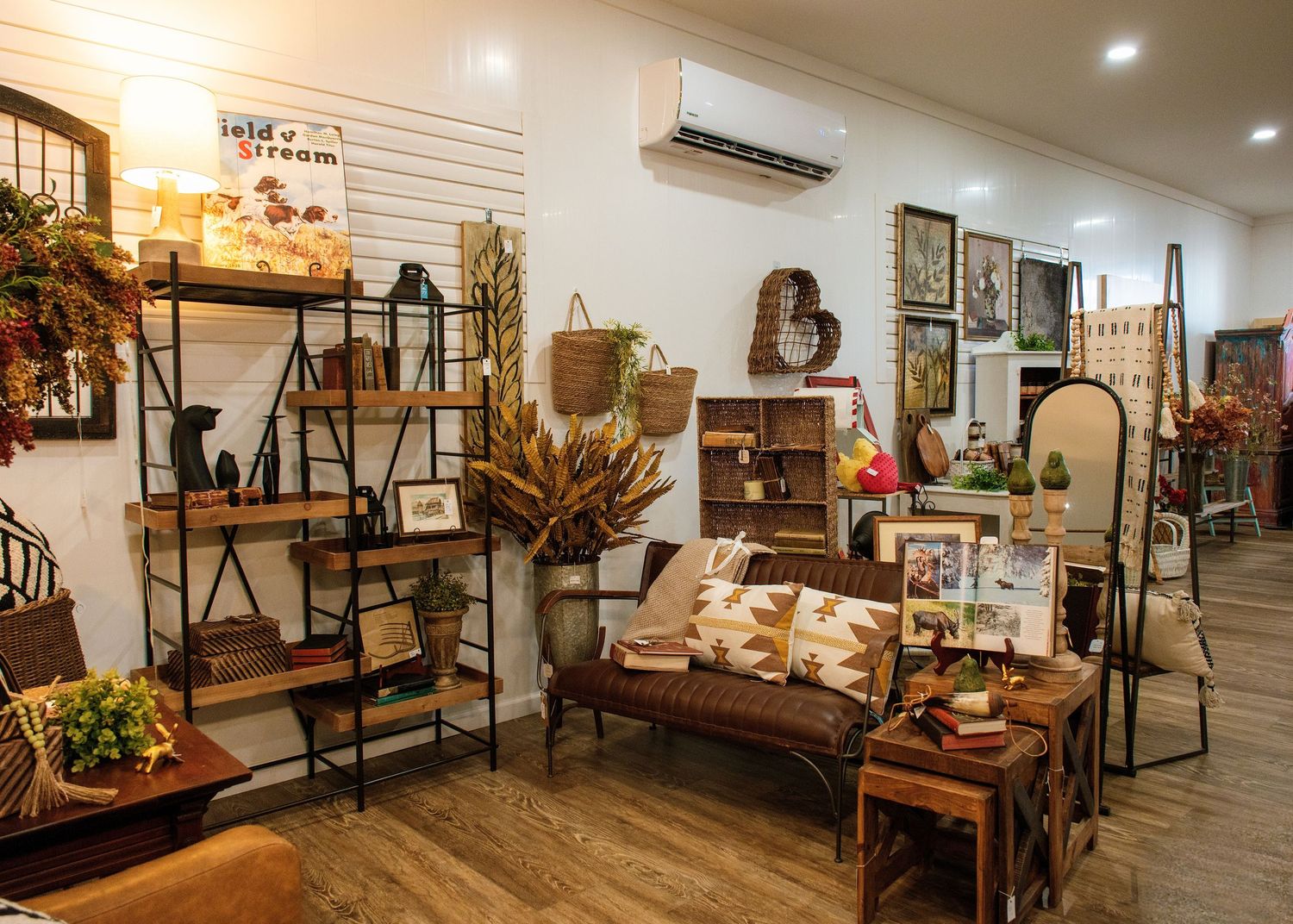 Interior view of a rustic retail store with wooden furniture and home decor displays.