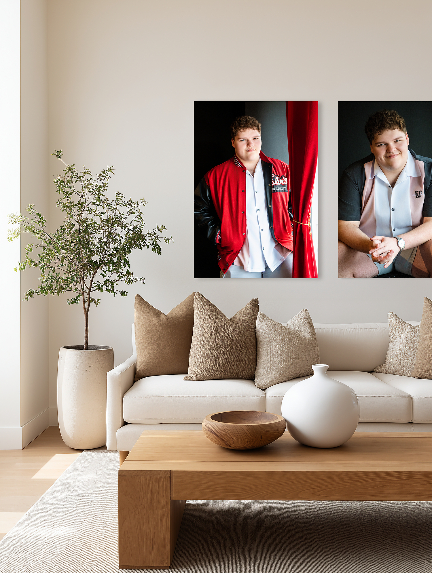 Modern living room interior with beige sofa, wooden coffee table, potted plant and framed portraits on white wall.