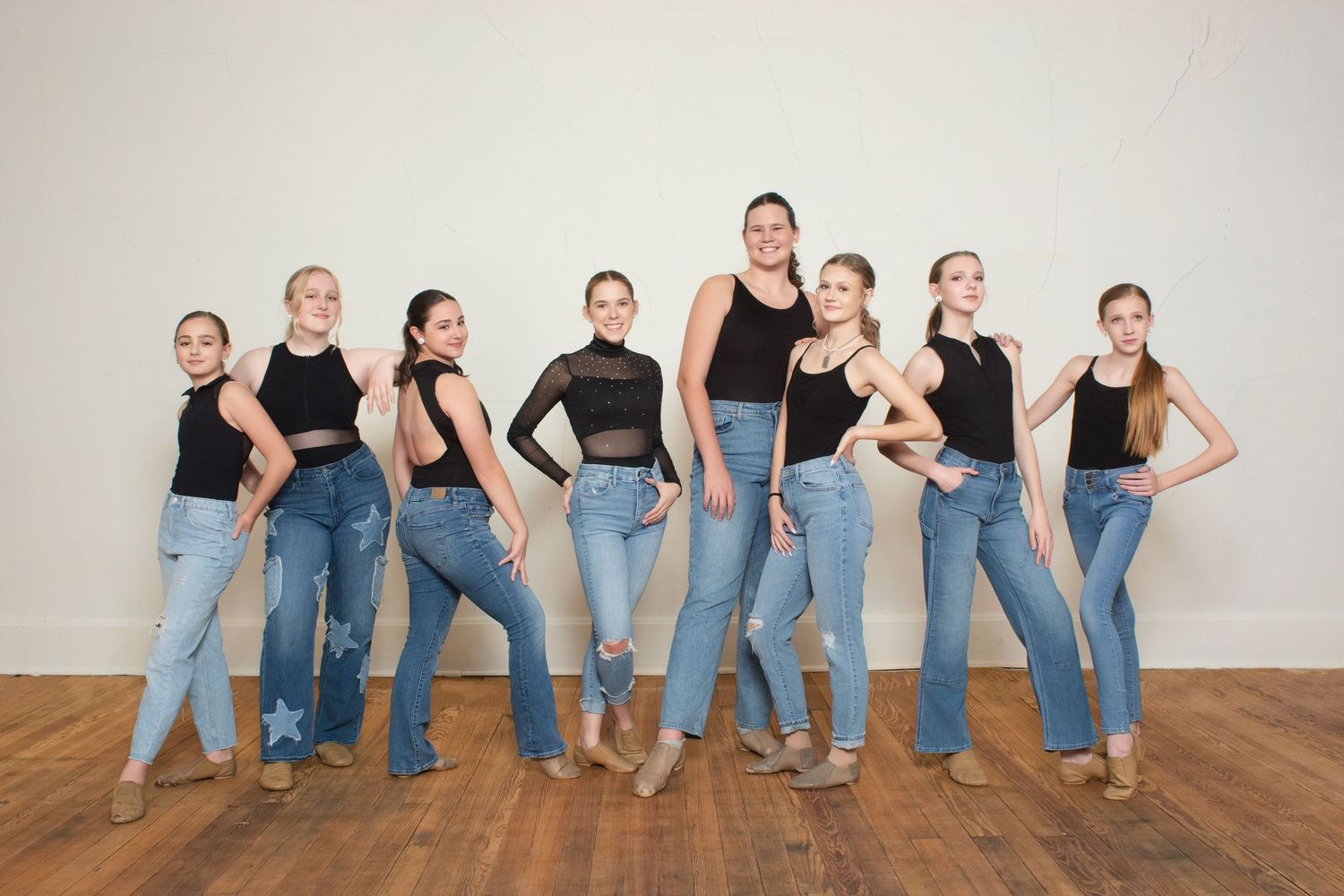 Group photo showing casual poses against white studio wall.