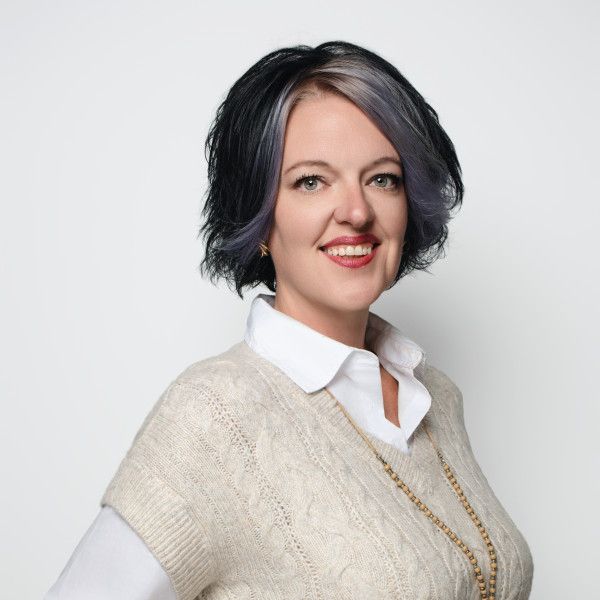 Portrait series showing someone in a white collared shirt and cream sweater with jewelry.