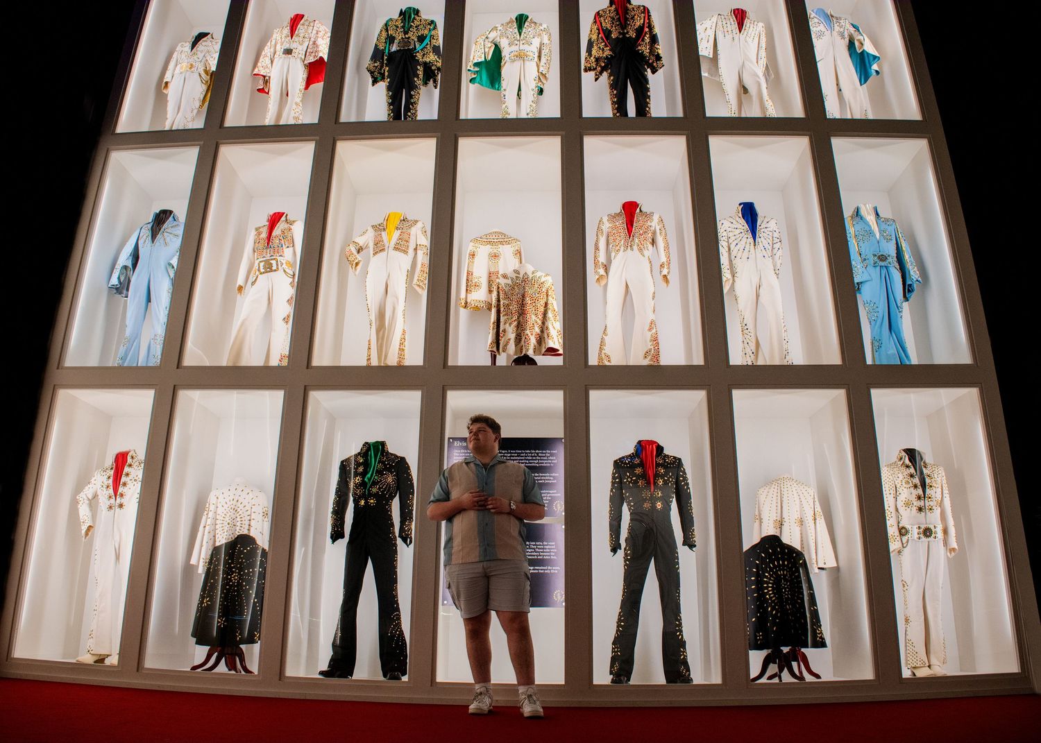 A series of illuminated window displays showcasing fashion mannequins wearing various clothing styles and outfits.