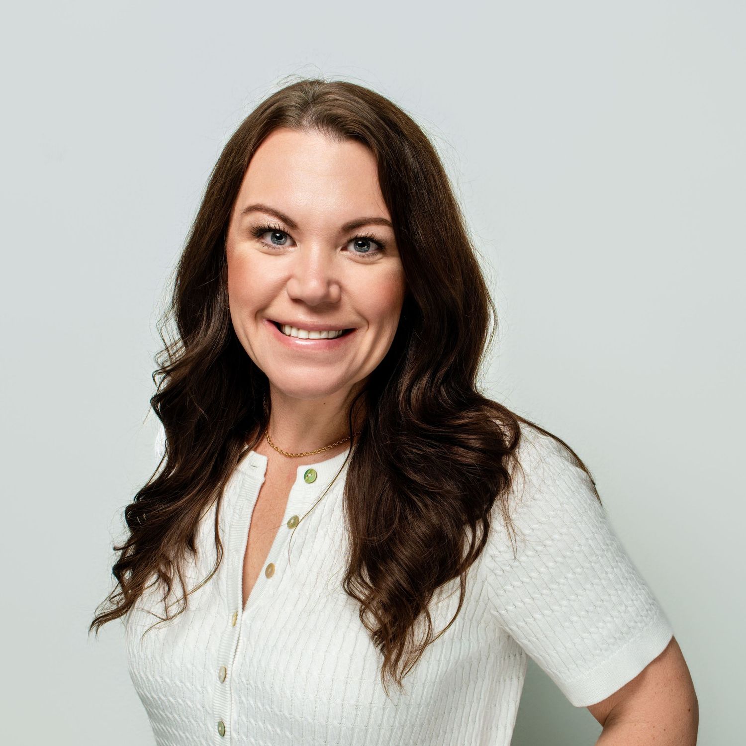 Studio portraits of someone in a white button-down shirt against a light background.