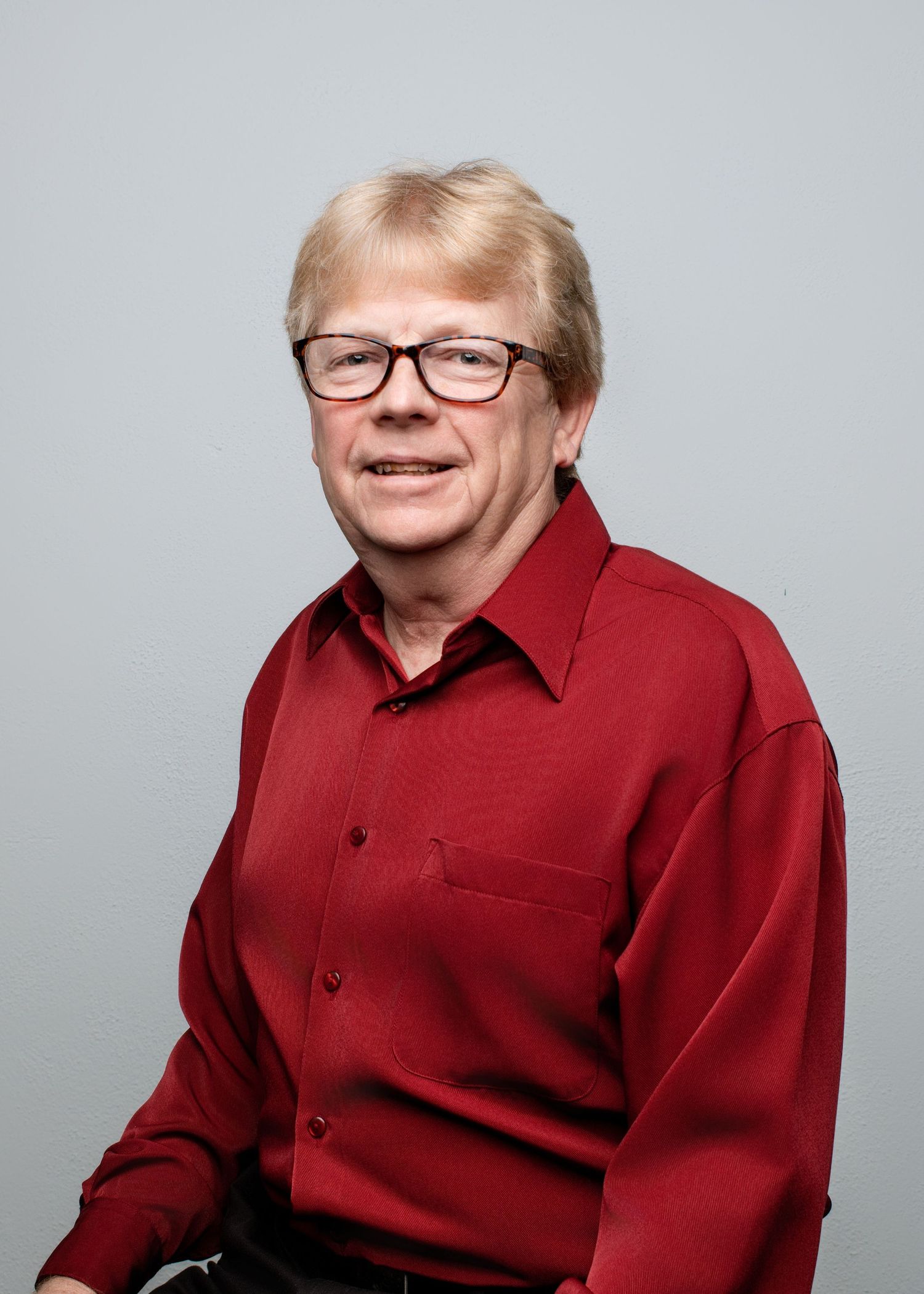 Portrait series showing someone in a burgundy button-up shirt and glasses.