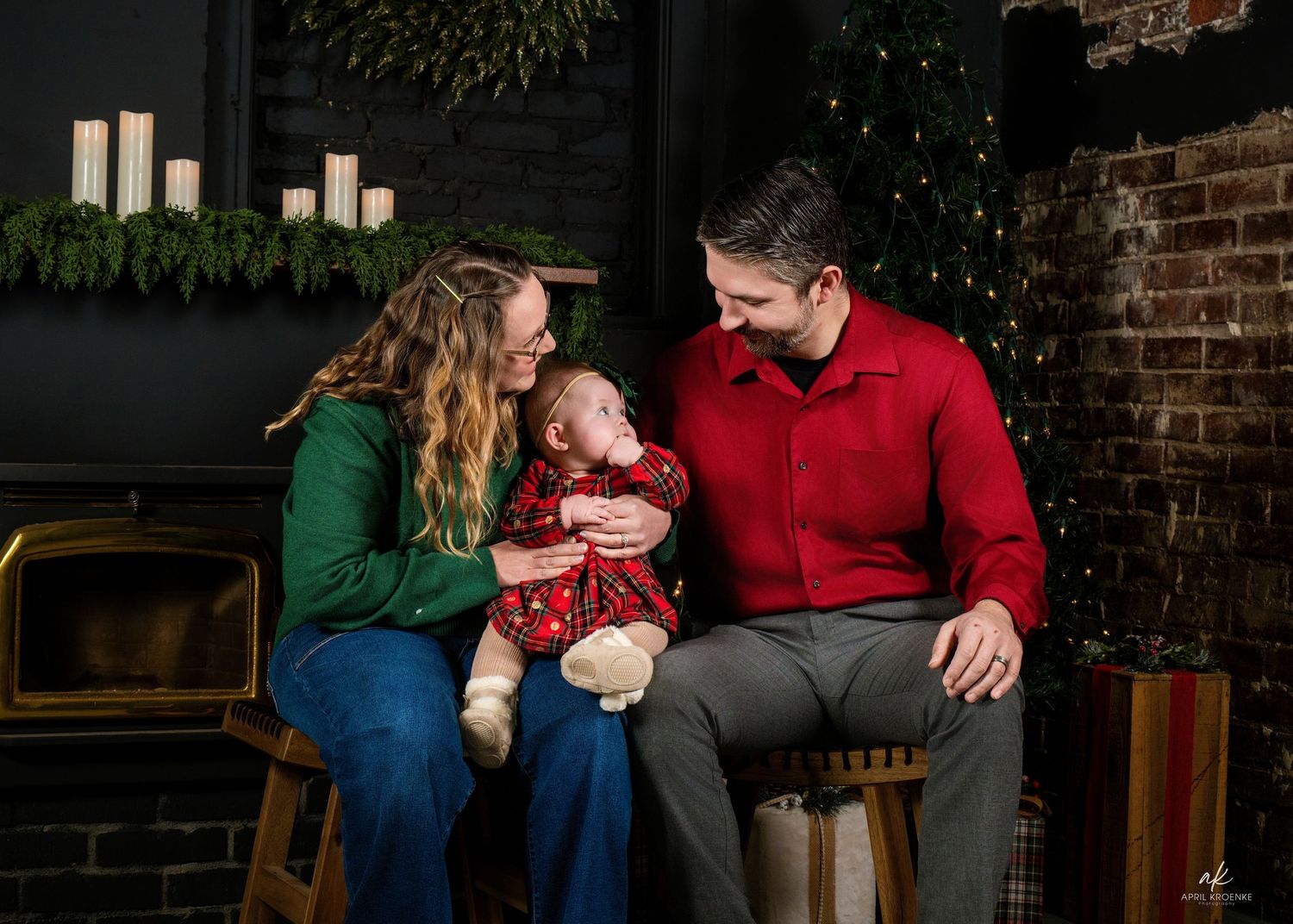 Cozy indoor holiday scene with people sitting on furniture near Christmas decorations.
