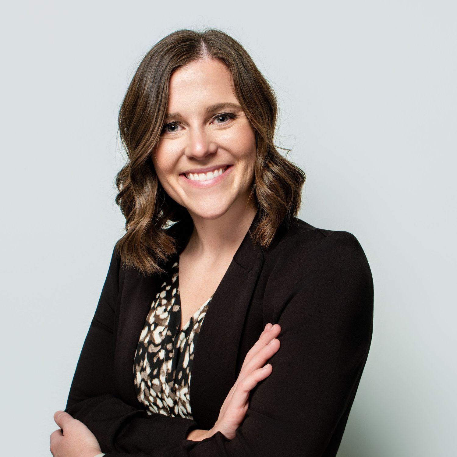 Studio portraits featuring someone in a black blazer and patterned top.